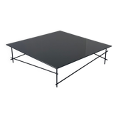 Minimalist black glass coffee table with industrial metal base