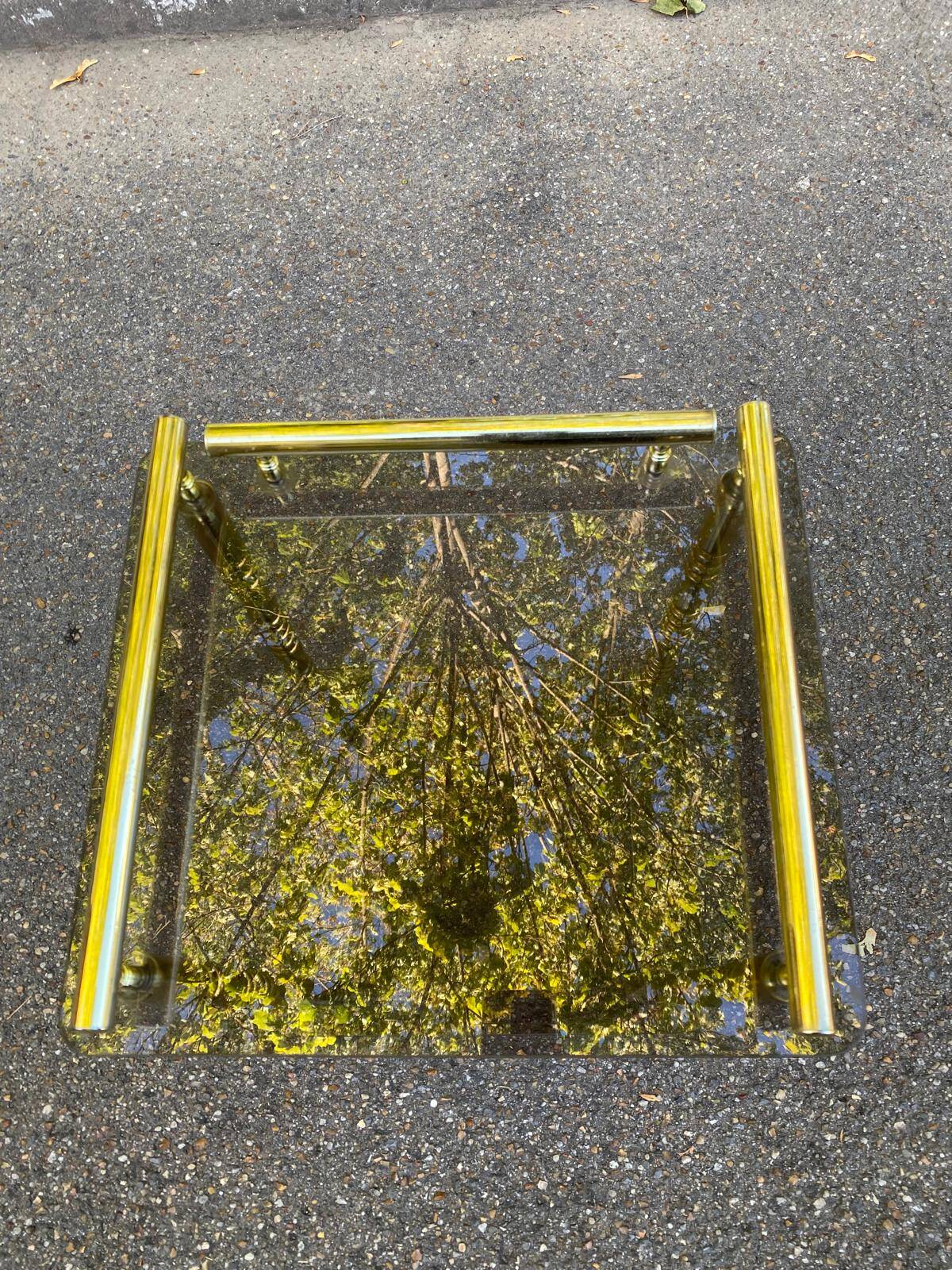 Vintage side table with smoked glass and sculpted golden brass, Hollywood Regency style.