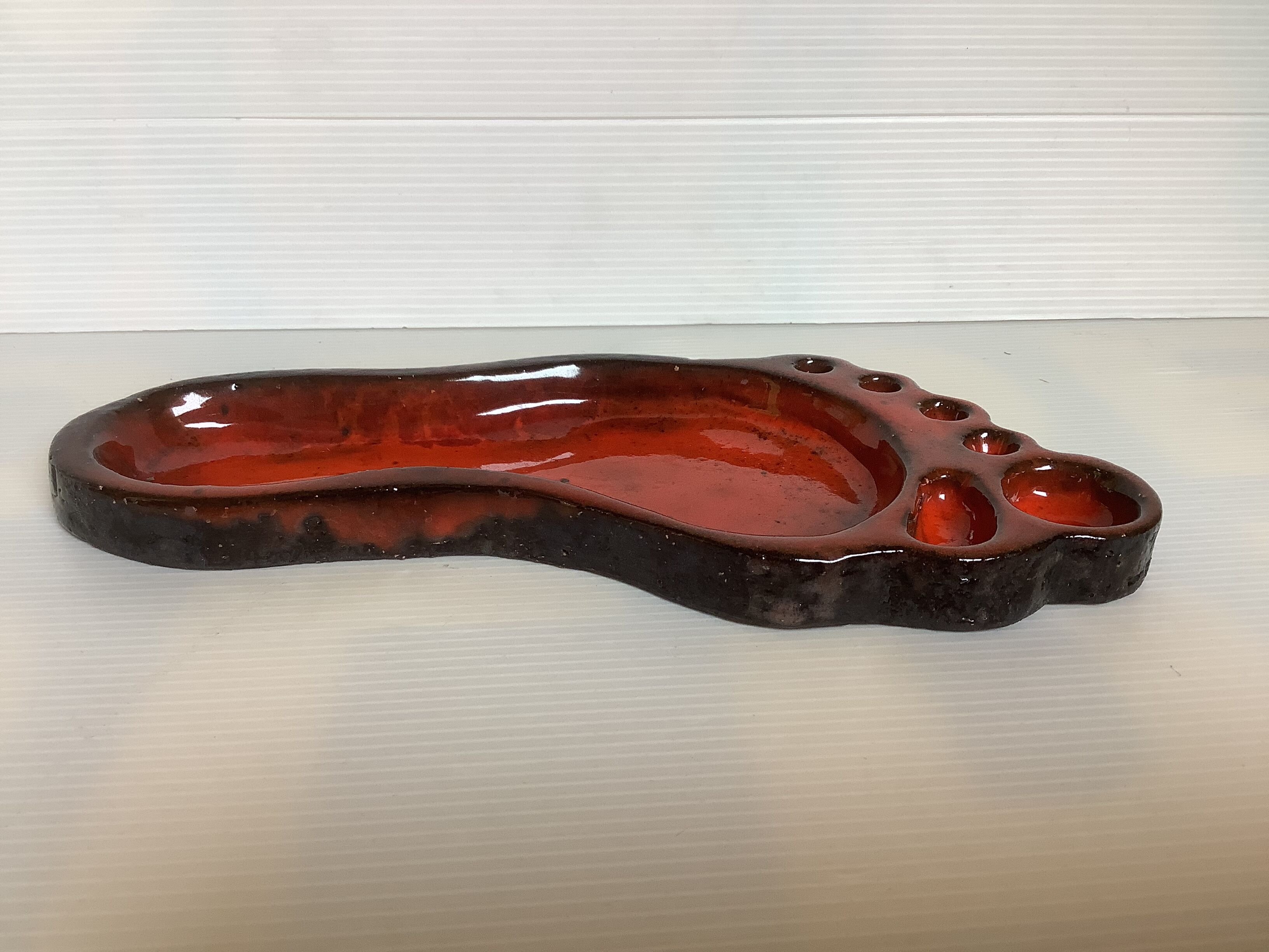 Red ceramic footprint catchall.