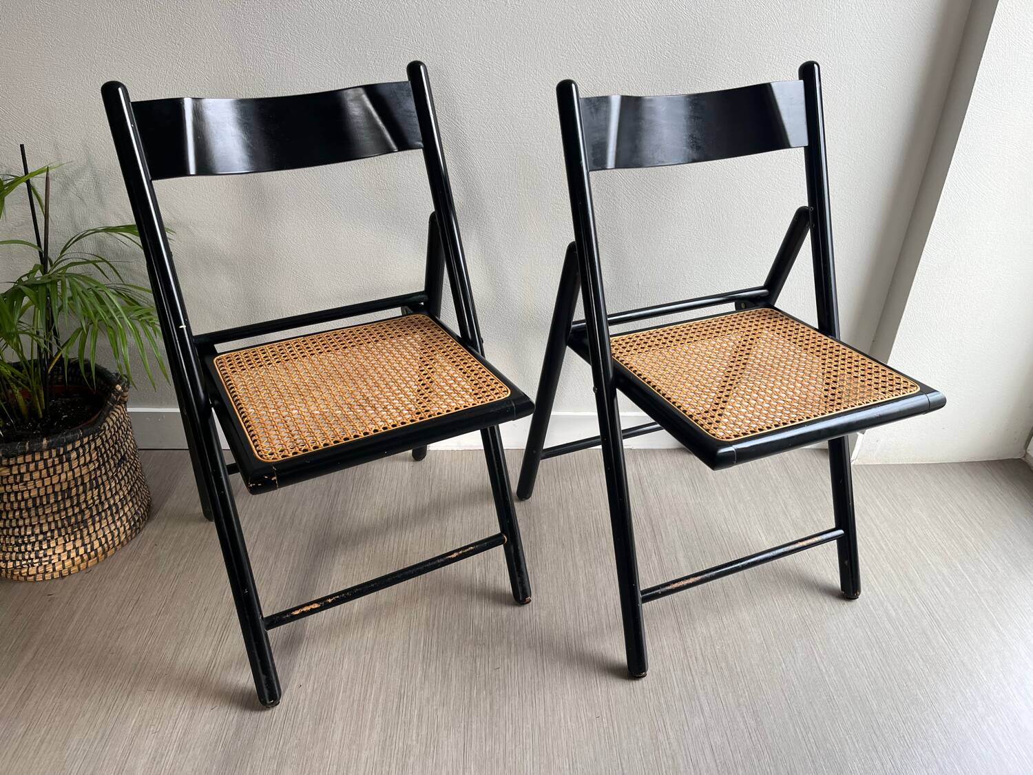 Vintage folding chairs in black wood and cane.