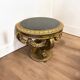 A round Louis XV style table in carved gilt beechwood with a black marble top