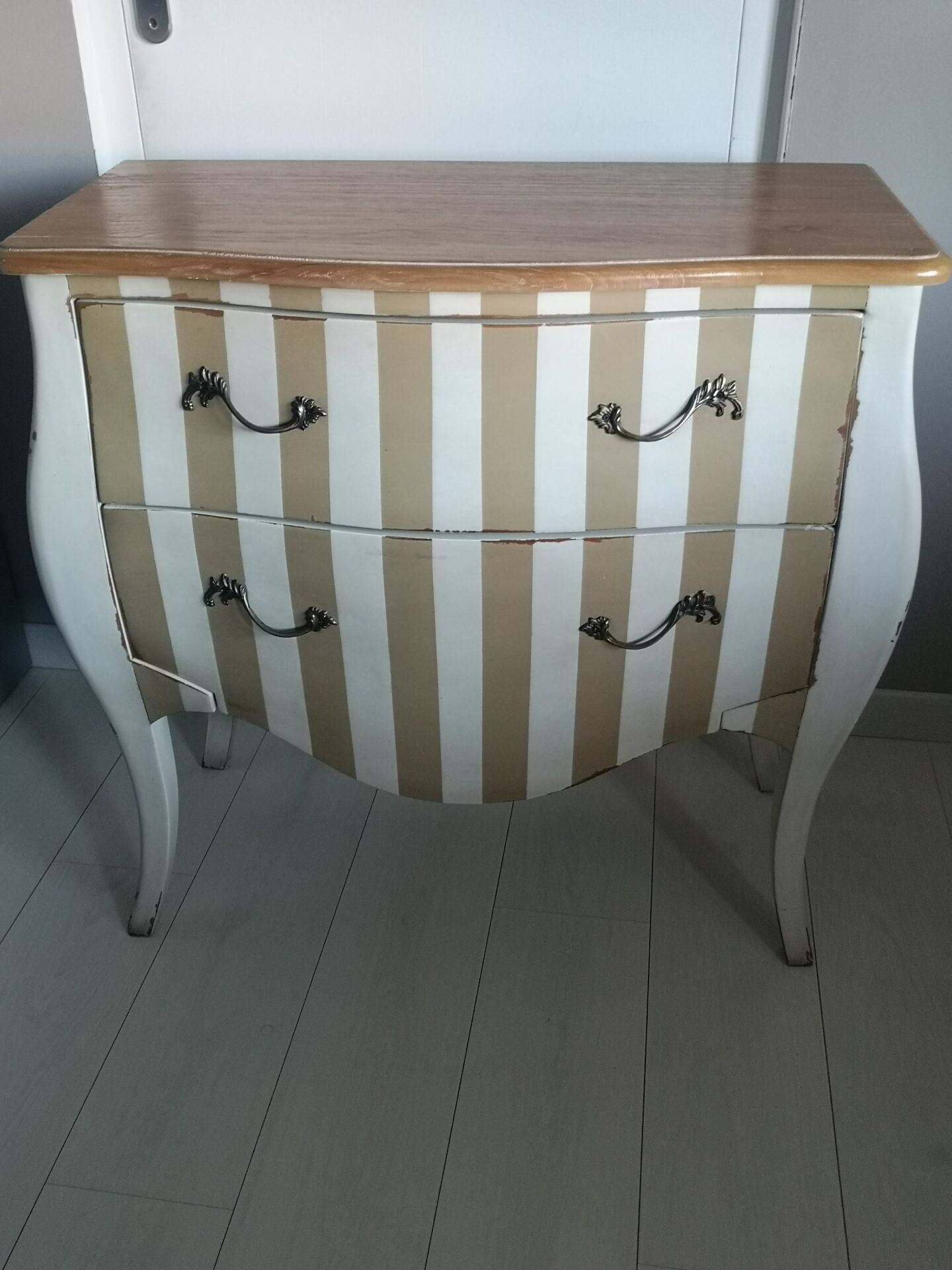 Curved commode with beige and white stripes.