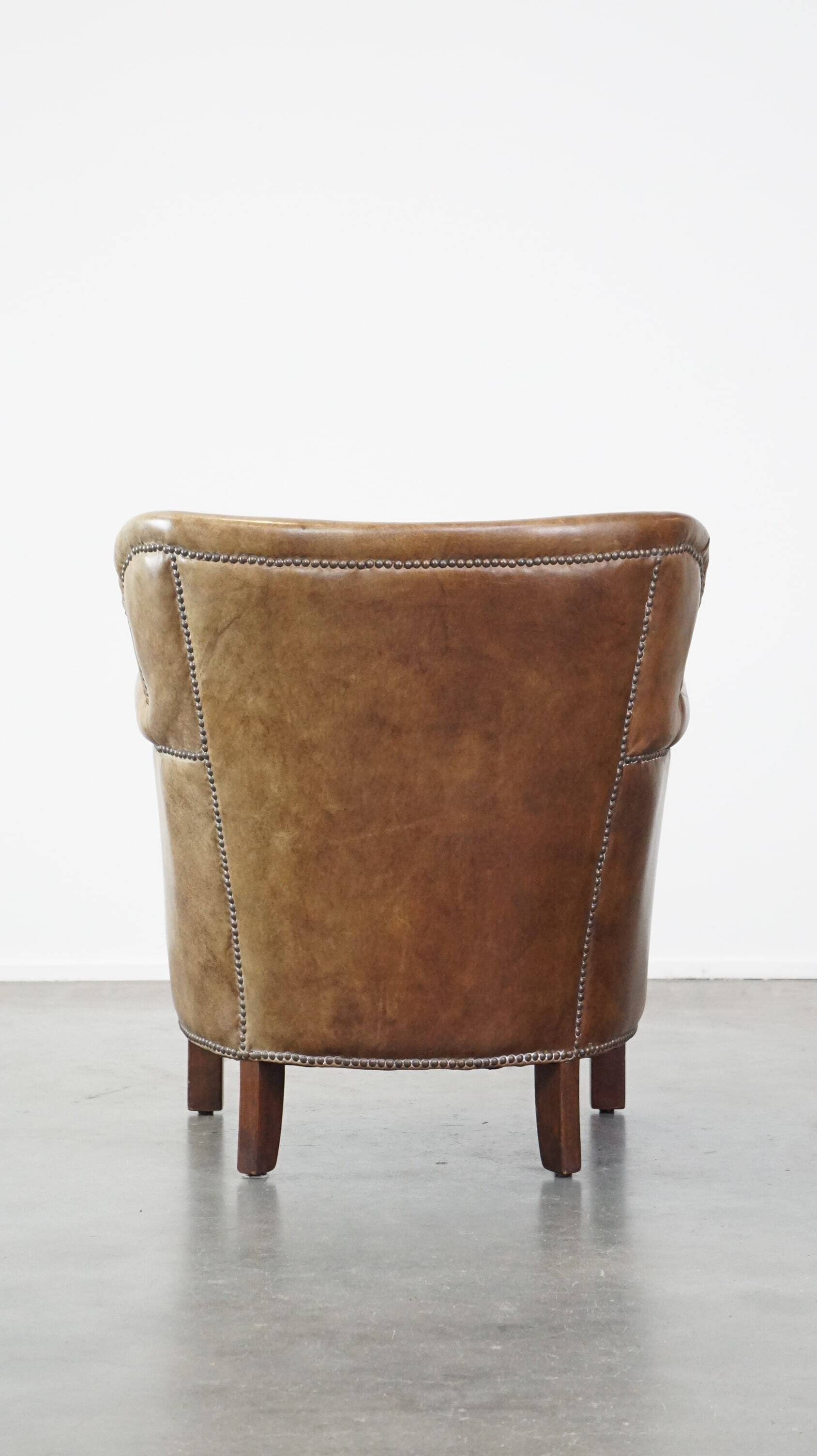 Subtle leather armchair with a reversible kilim seat cushion