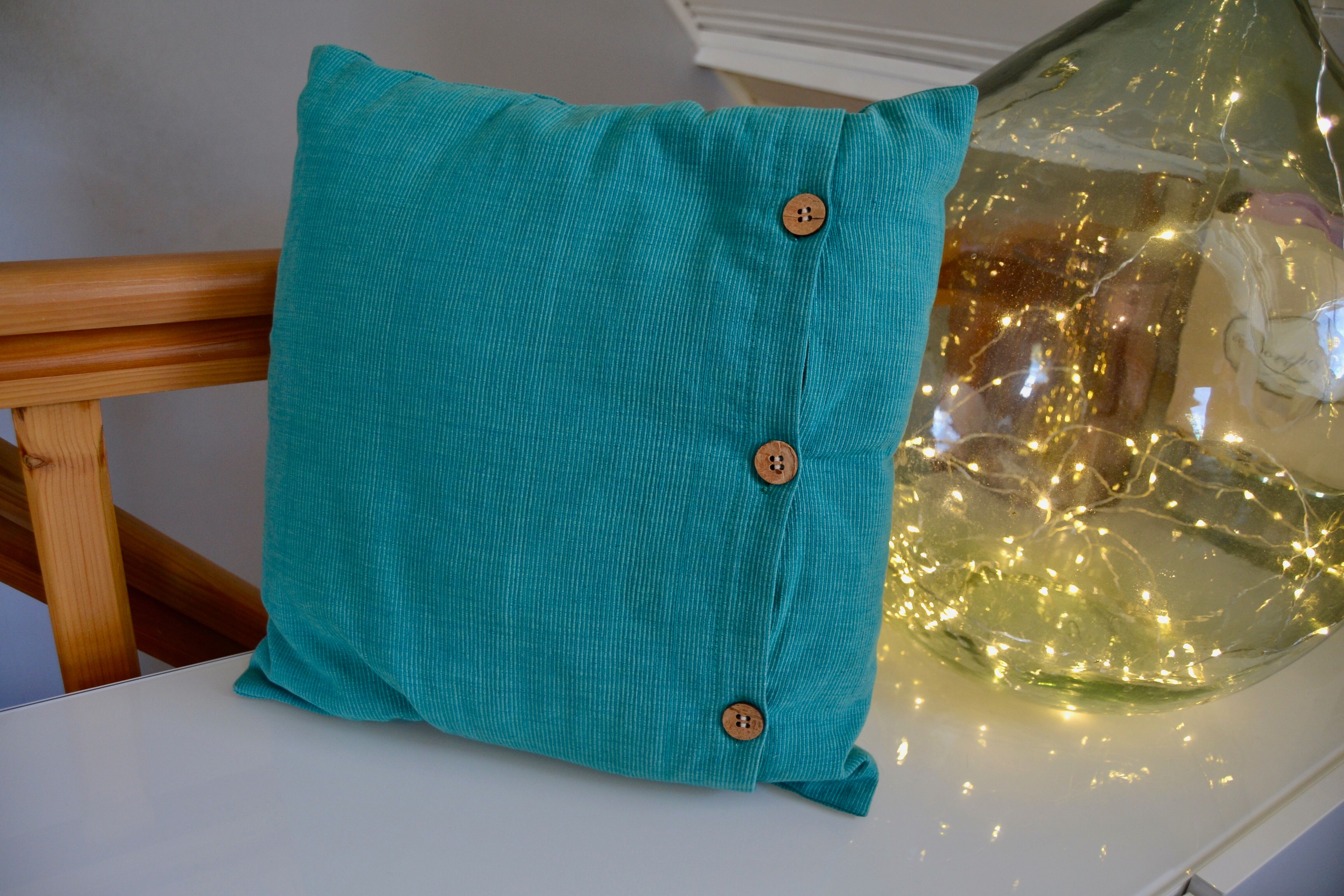 Scandinavian green cushion with wooden buttons