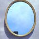 Oval mirror in gold metal