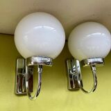 Pair of chrome metal wall lights with white glass globe.