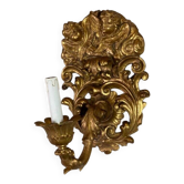 Pair of sculpted and gilded wooden wall sconces topped with two cherub heads, Italy.