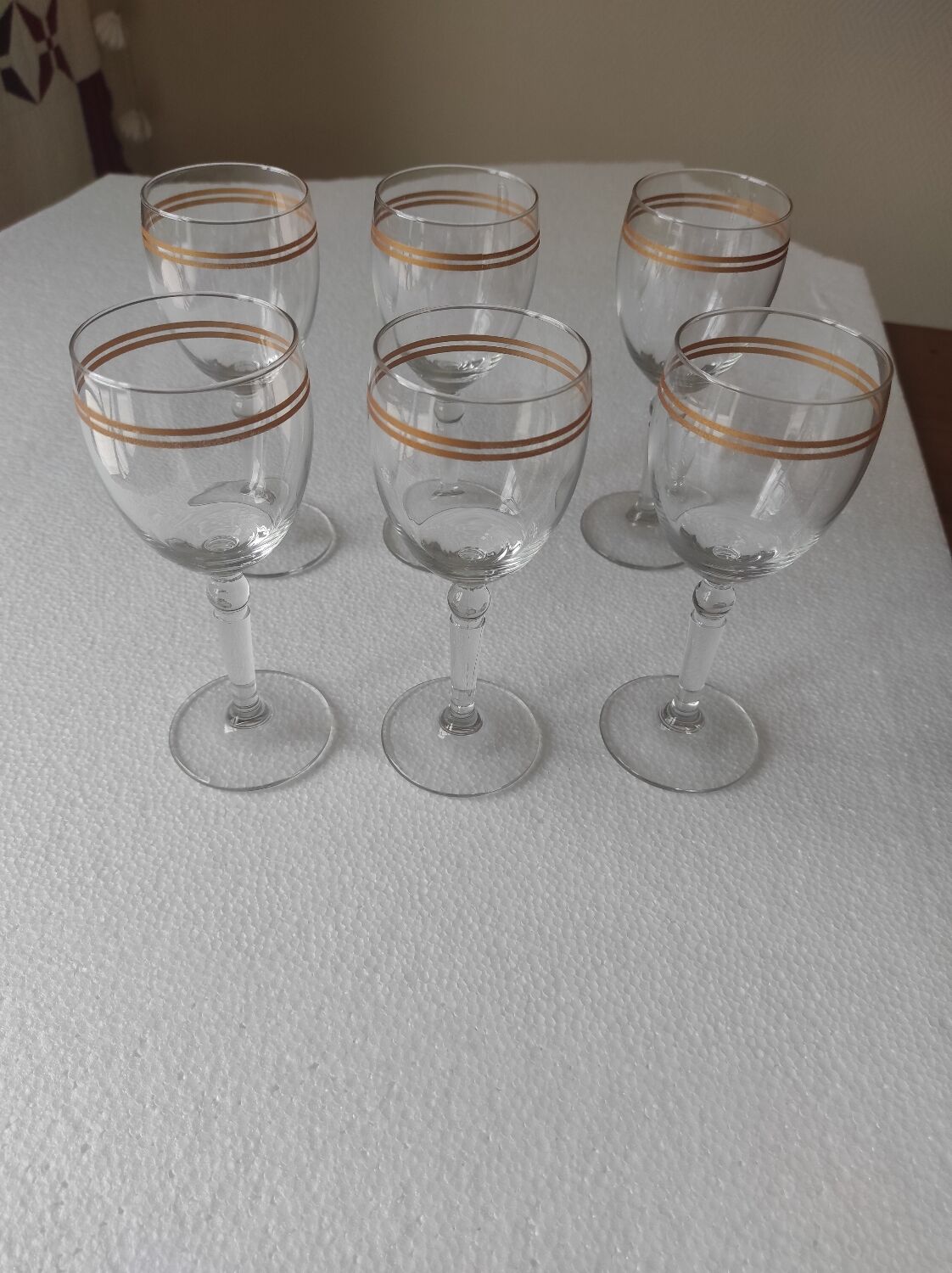 Set of 6 glasses with gold band decorations.