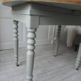 Walnut table with raised flaps, base on verdigris casters.