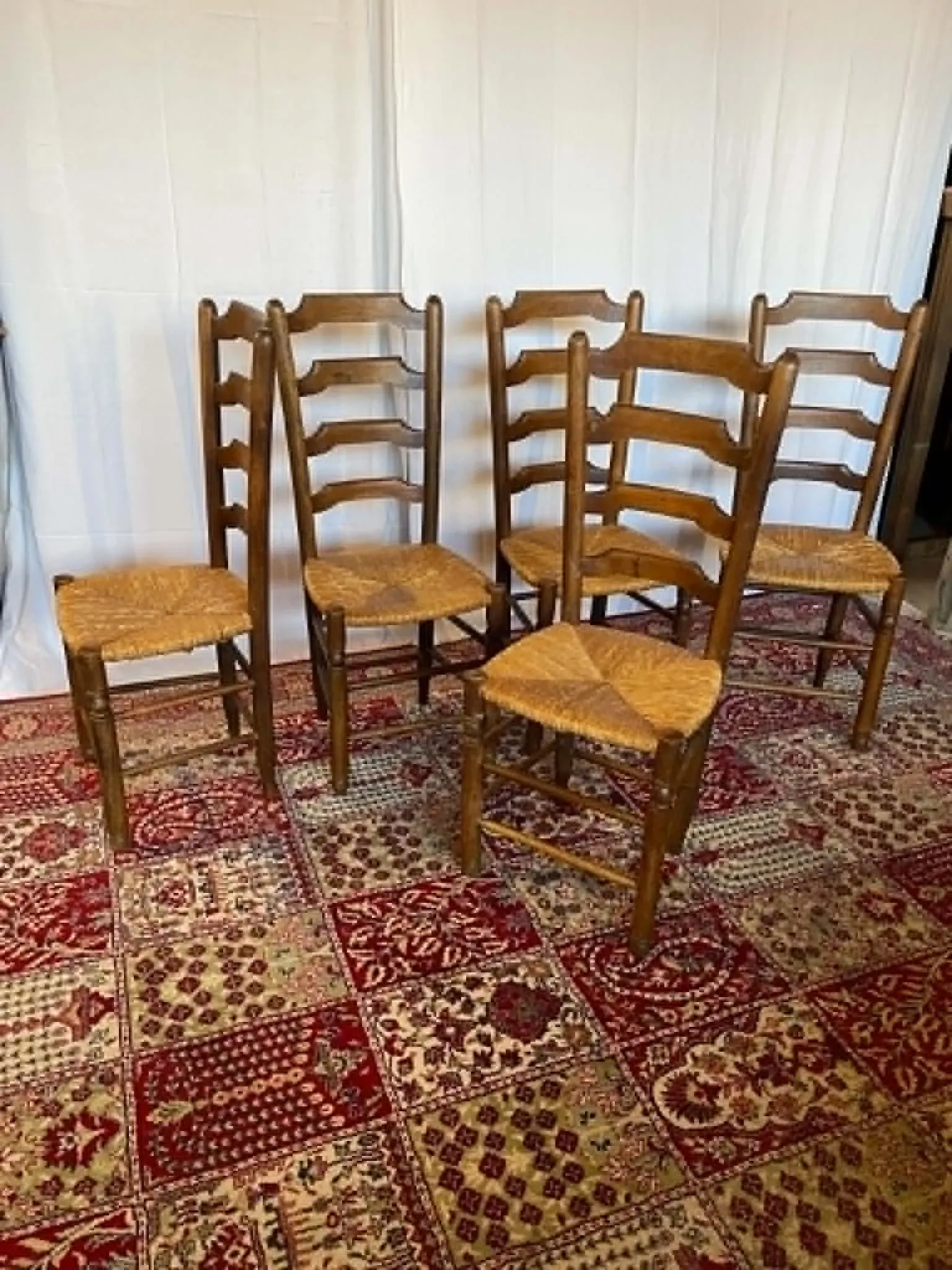 Set of 5 antique solid oak chairs with straw seats.
