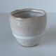 Meeting of three artist's ceramic objects including two pots and a cream covered bowl