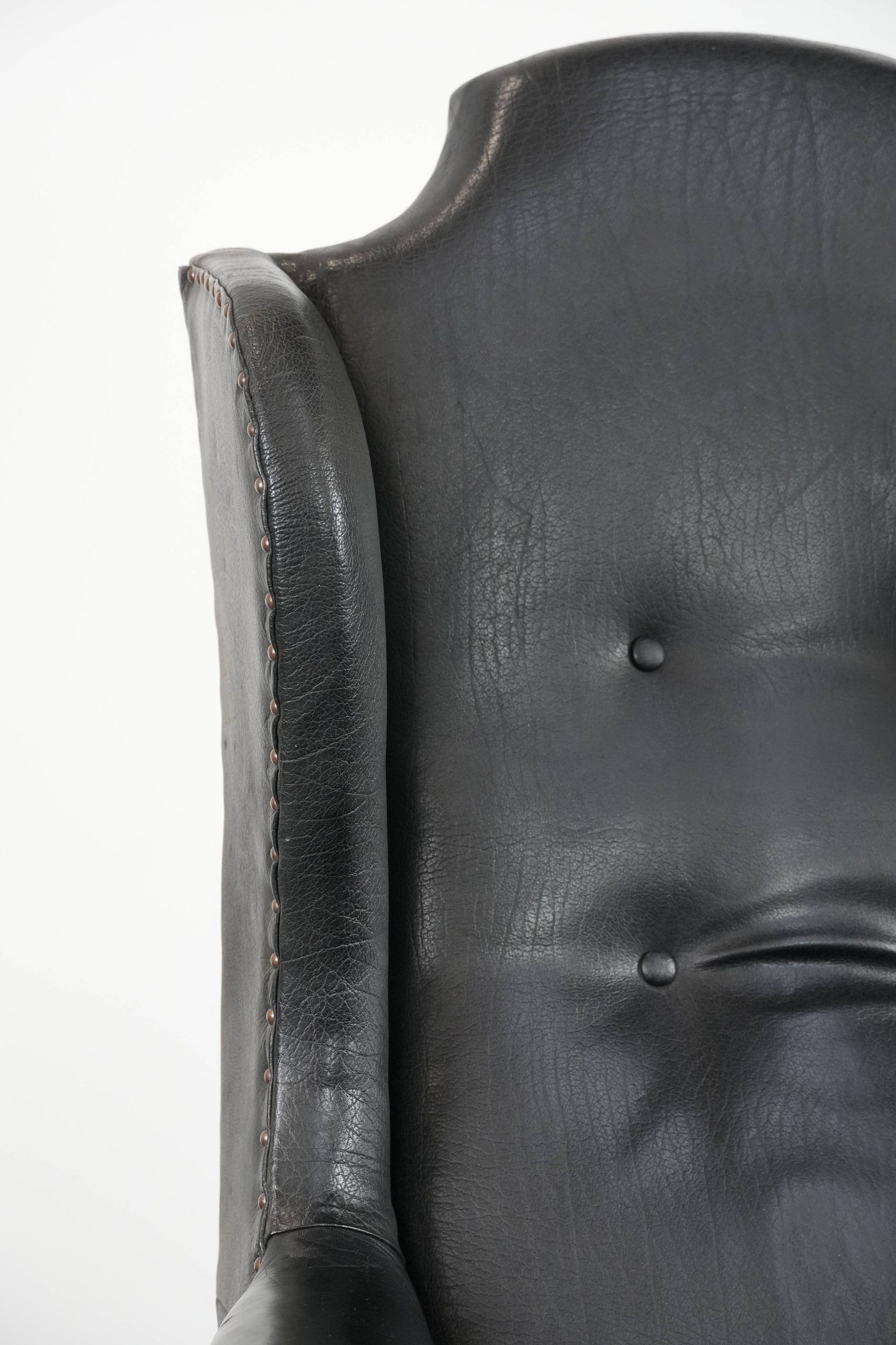Antique black English cow leather wingback armchair from the 19th century