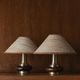Lot of 2 vintage table lamps from the 1970s, dark wood oval bases with curved brass details, handmade natural fibre lampshades, elegant lighting.