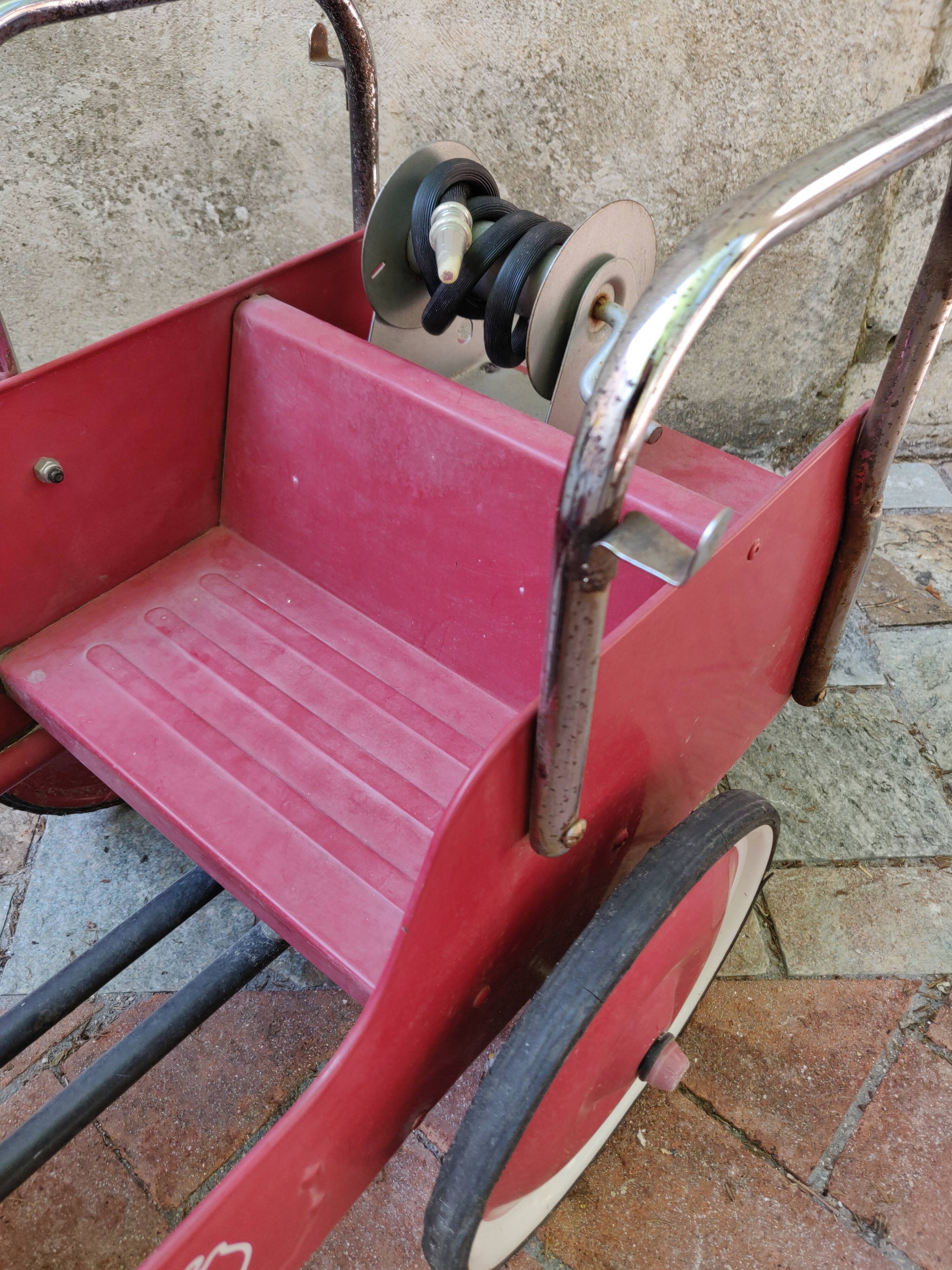 Old pedal car in tole fire truck