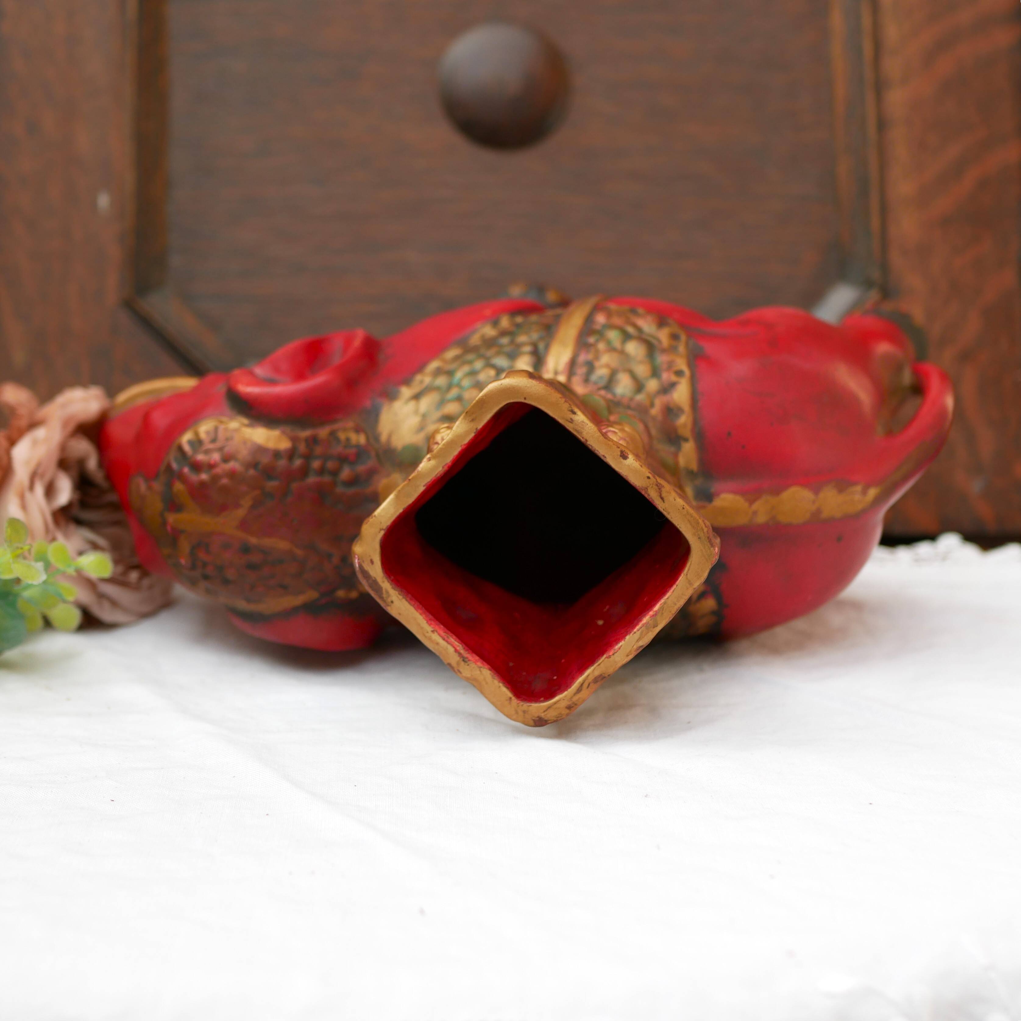 A pair of red and gold ceramic vases in the shape of elephants, 1940s.