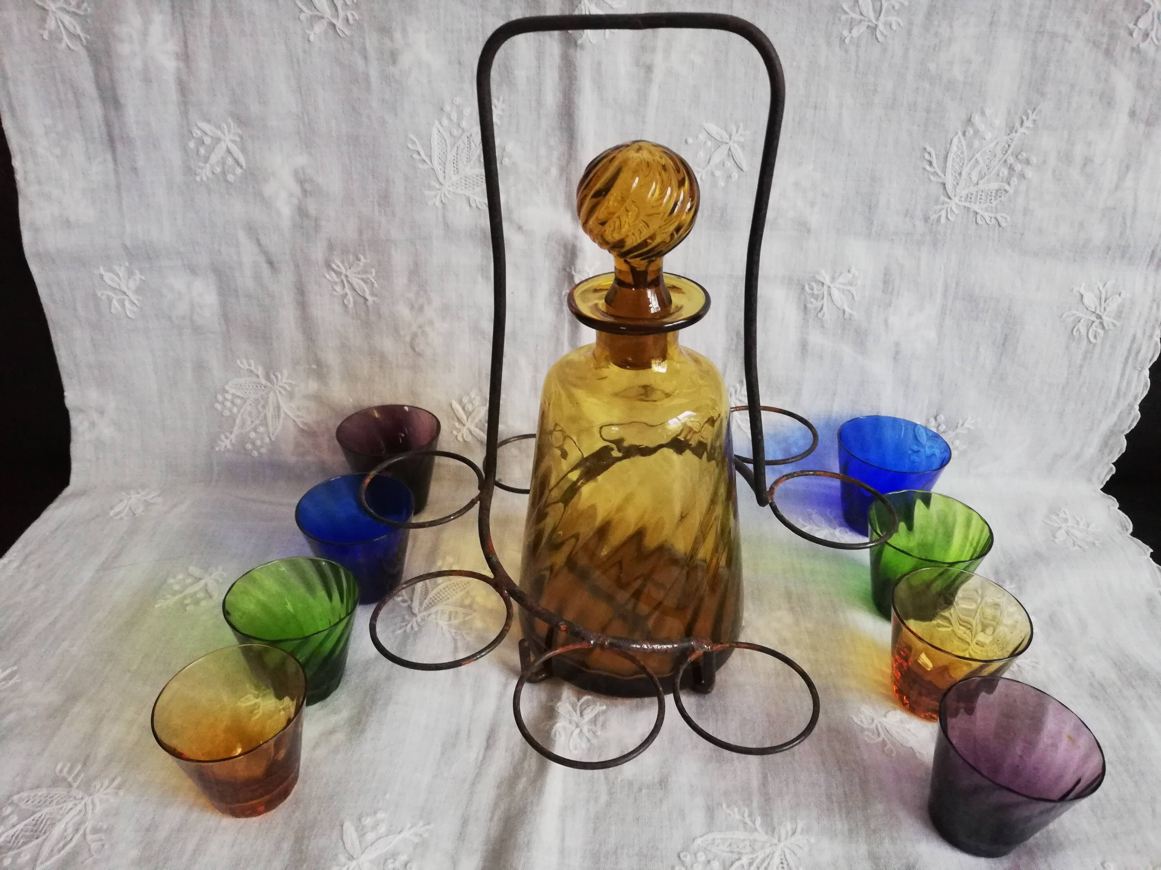 Old Italian alcohol decanter and its colorful glasses