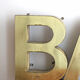 Old brass sign letters, word BAR