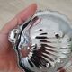 Scallop shell butter dish in stainless steel with its white glass saucer.