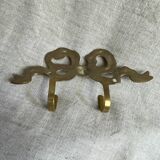 Two-hook coat rack with knot and ribbon in brass