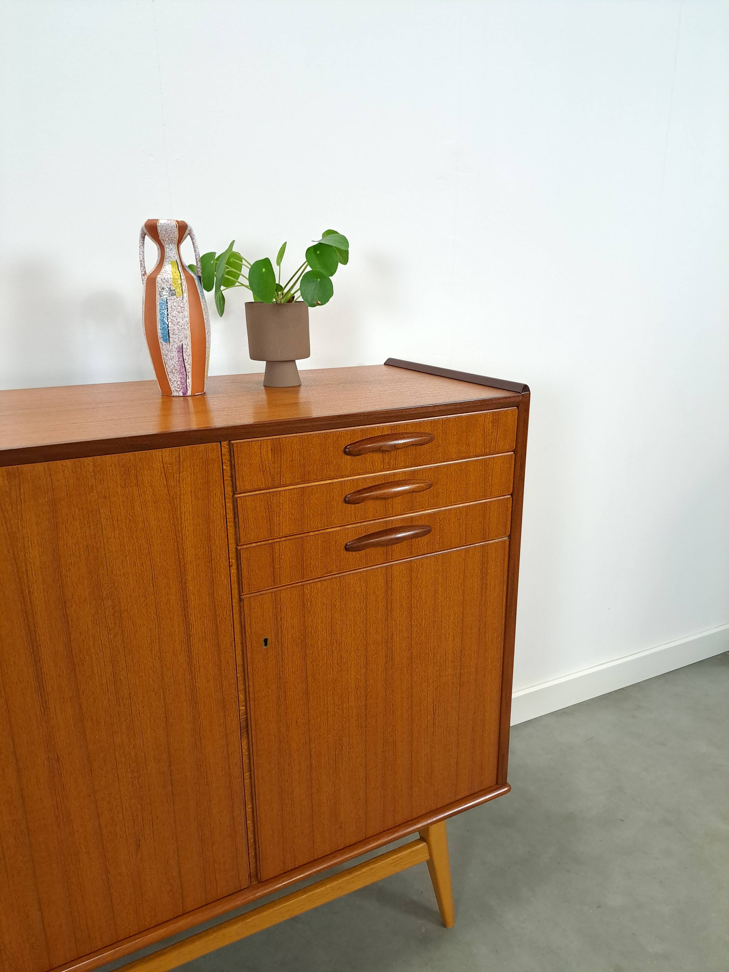 Teak kast met schuine poten en lades uit Zweden