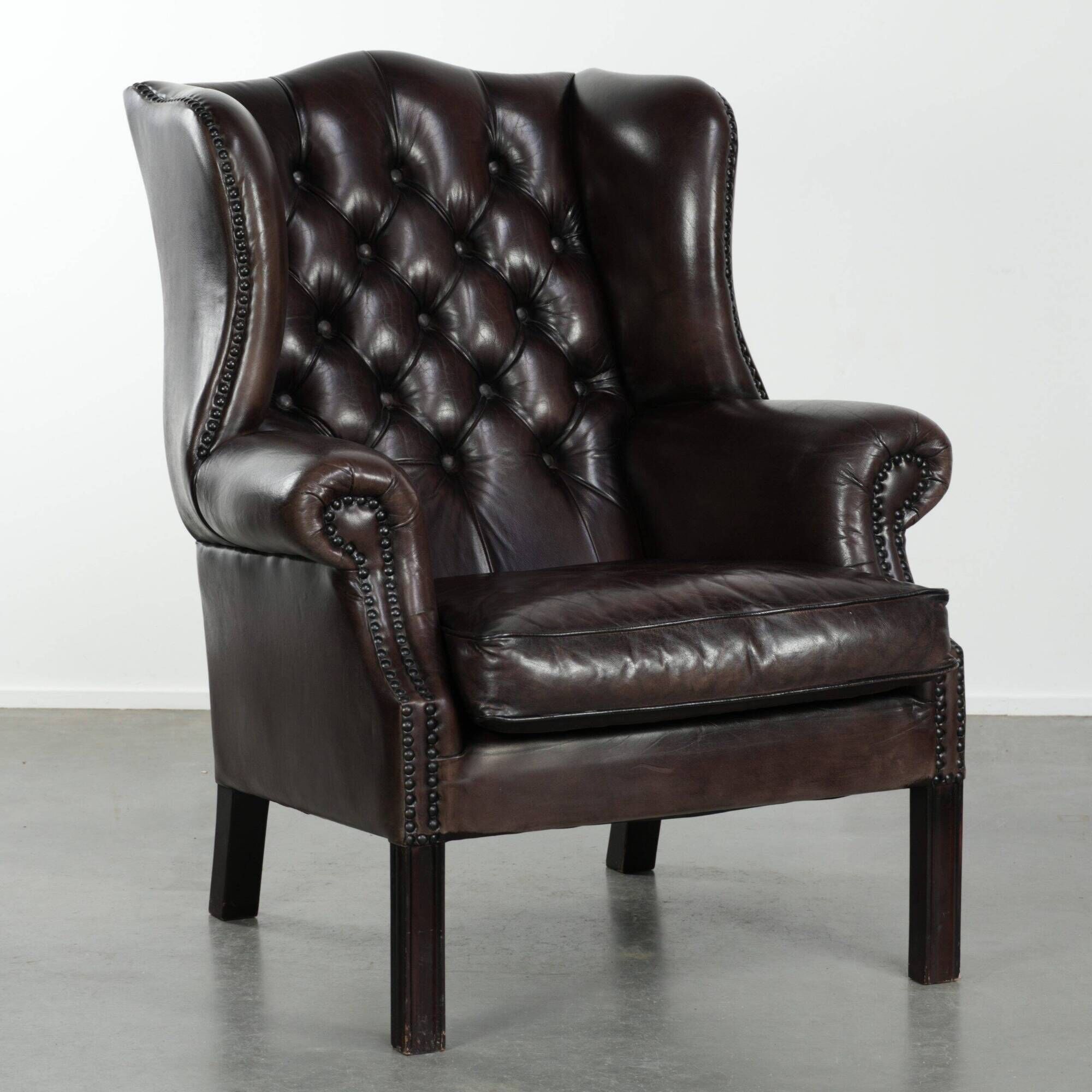 Dark brown cowhide Chesterfield wingback armchair in classic English style