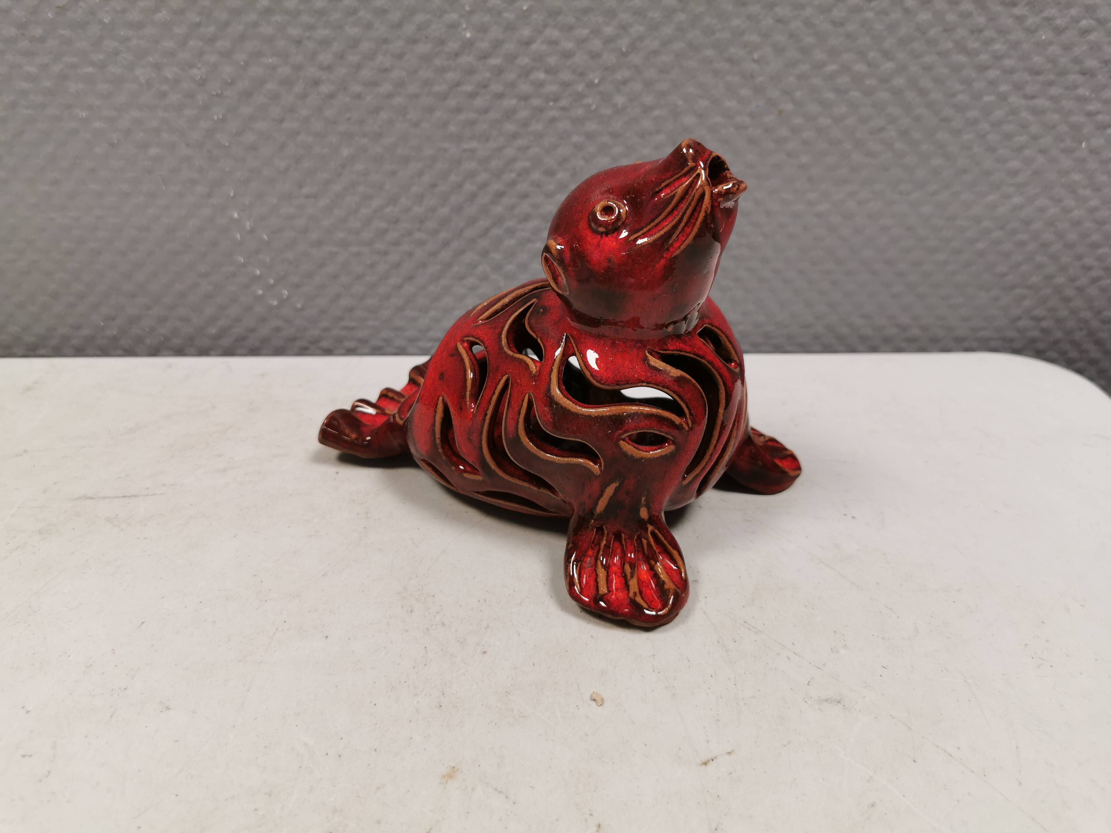 Beautiful seal in ceramic with metallic red glaze.