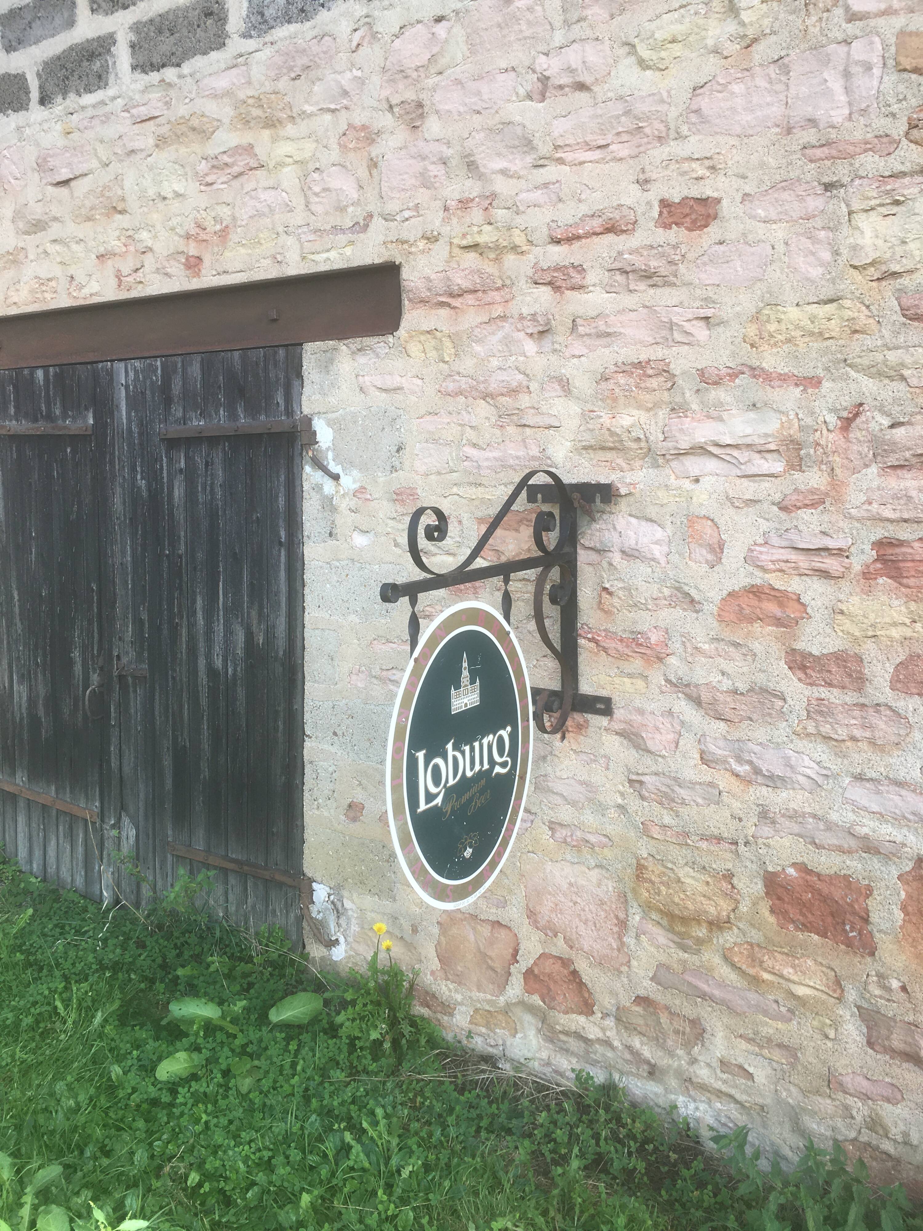 Double-sided "Loburg Beer" metal sign on wrought iron bracket