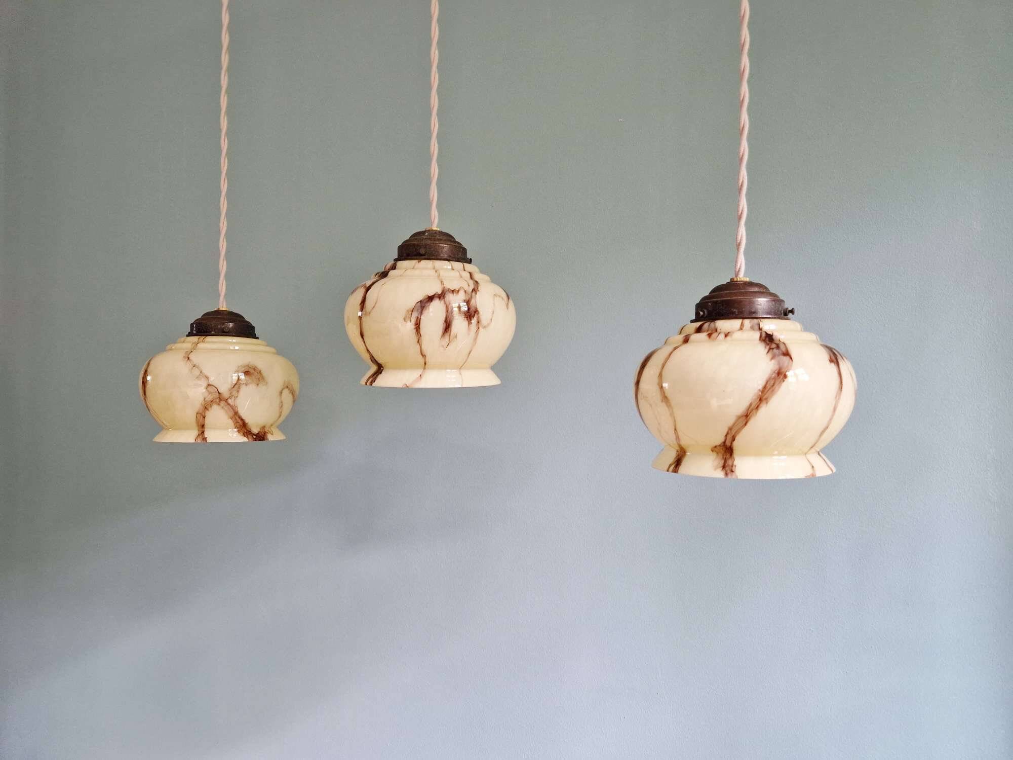 Trio of Art Deco marbled opaline pendant lights, 1920-30