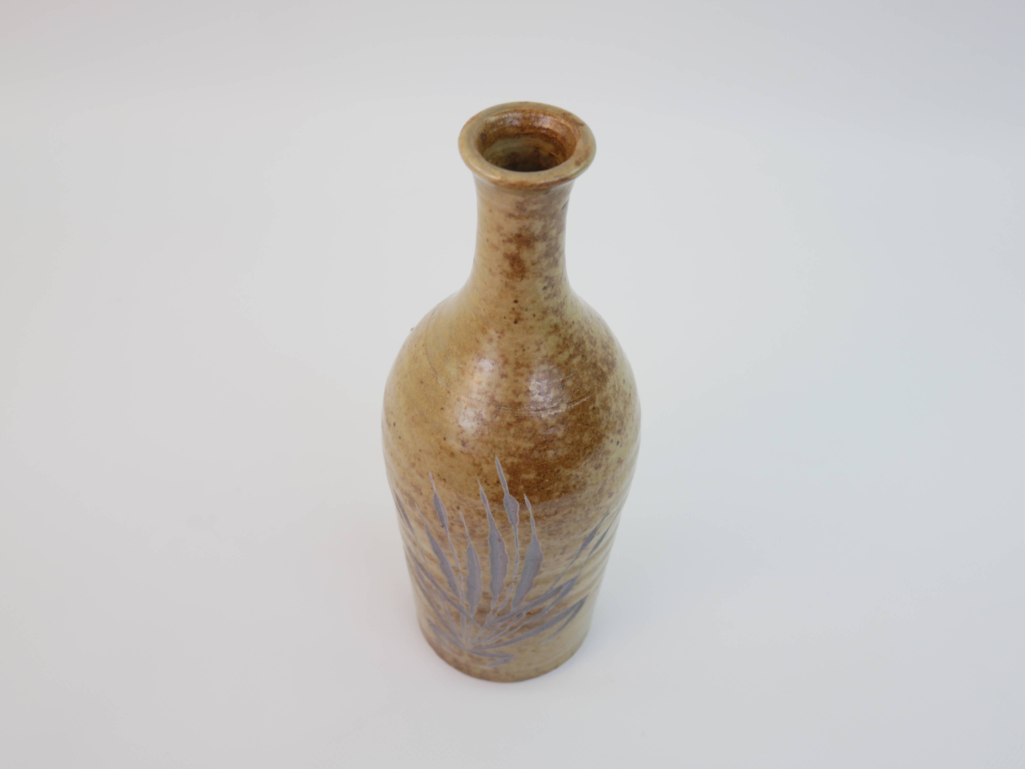 Brown ceramic/stoneware bottle with chiseled floral pattern