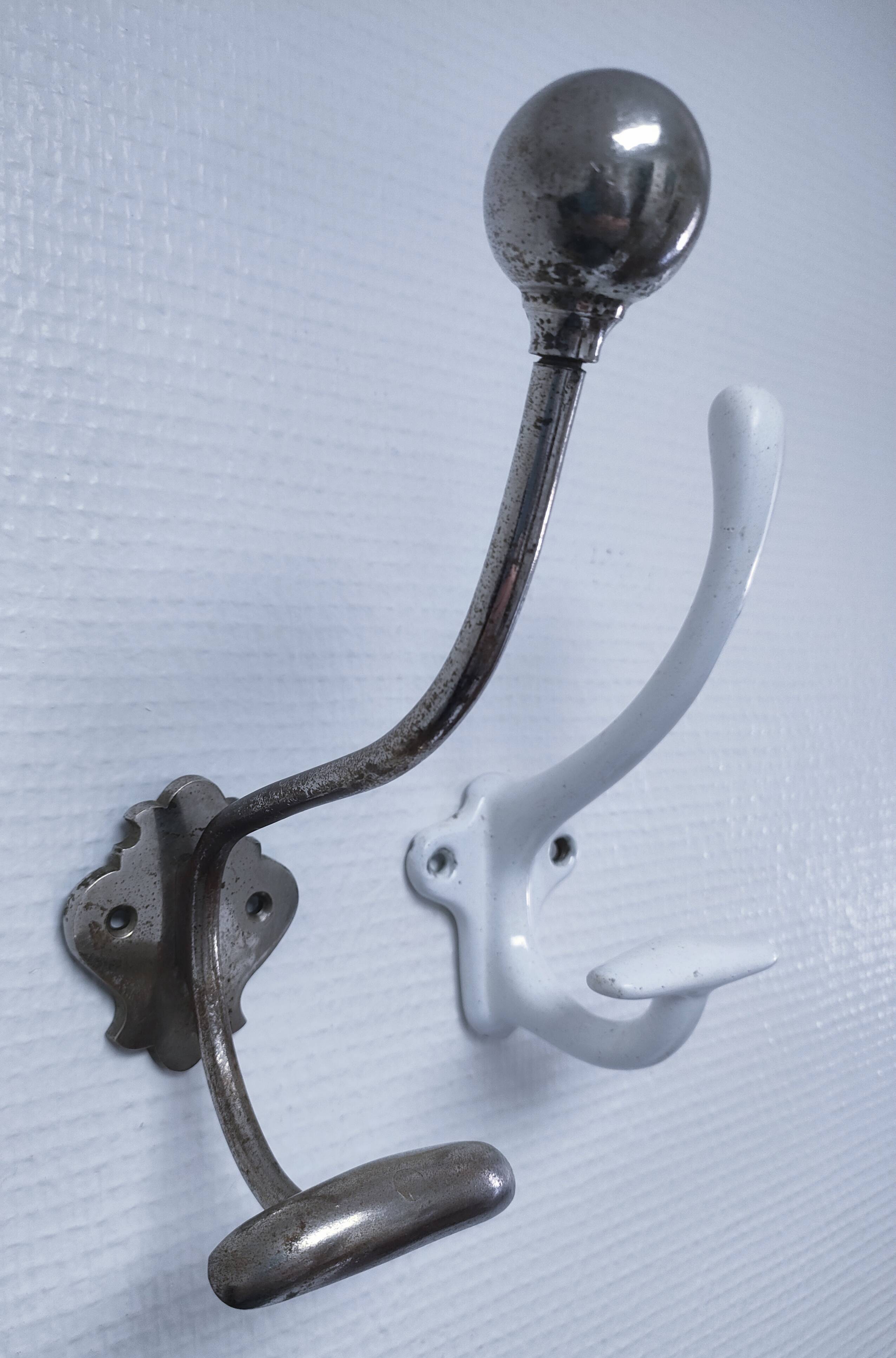 Three enameled cast iron coat hooks and vintage patina metal