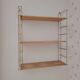 Vintage modular wall shelf in golden steel wire and wood from the 1950s.