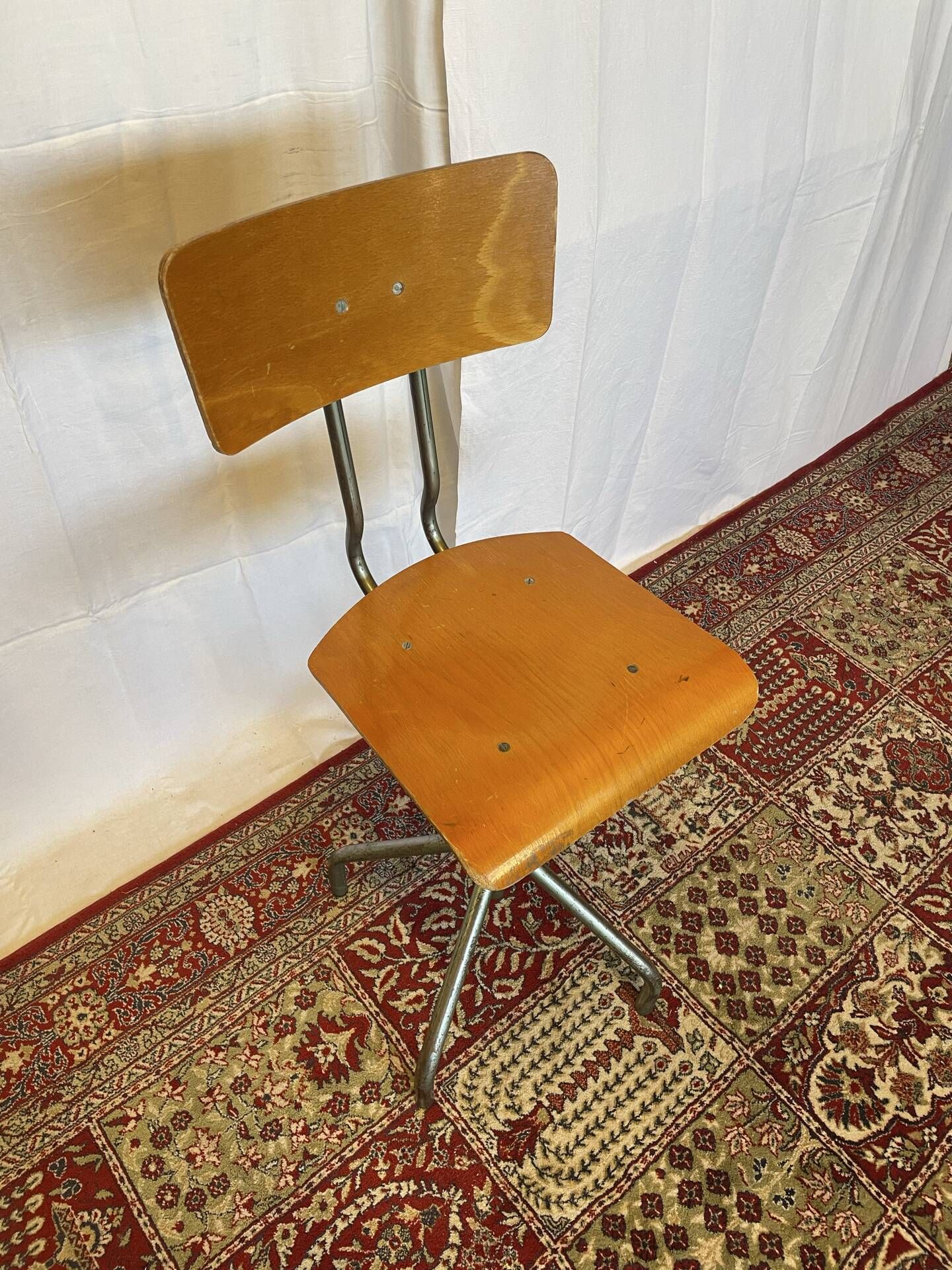 Old high workshop chair made of wood and metal.