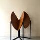 Modernist round folding dining table in wood and metal.