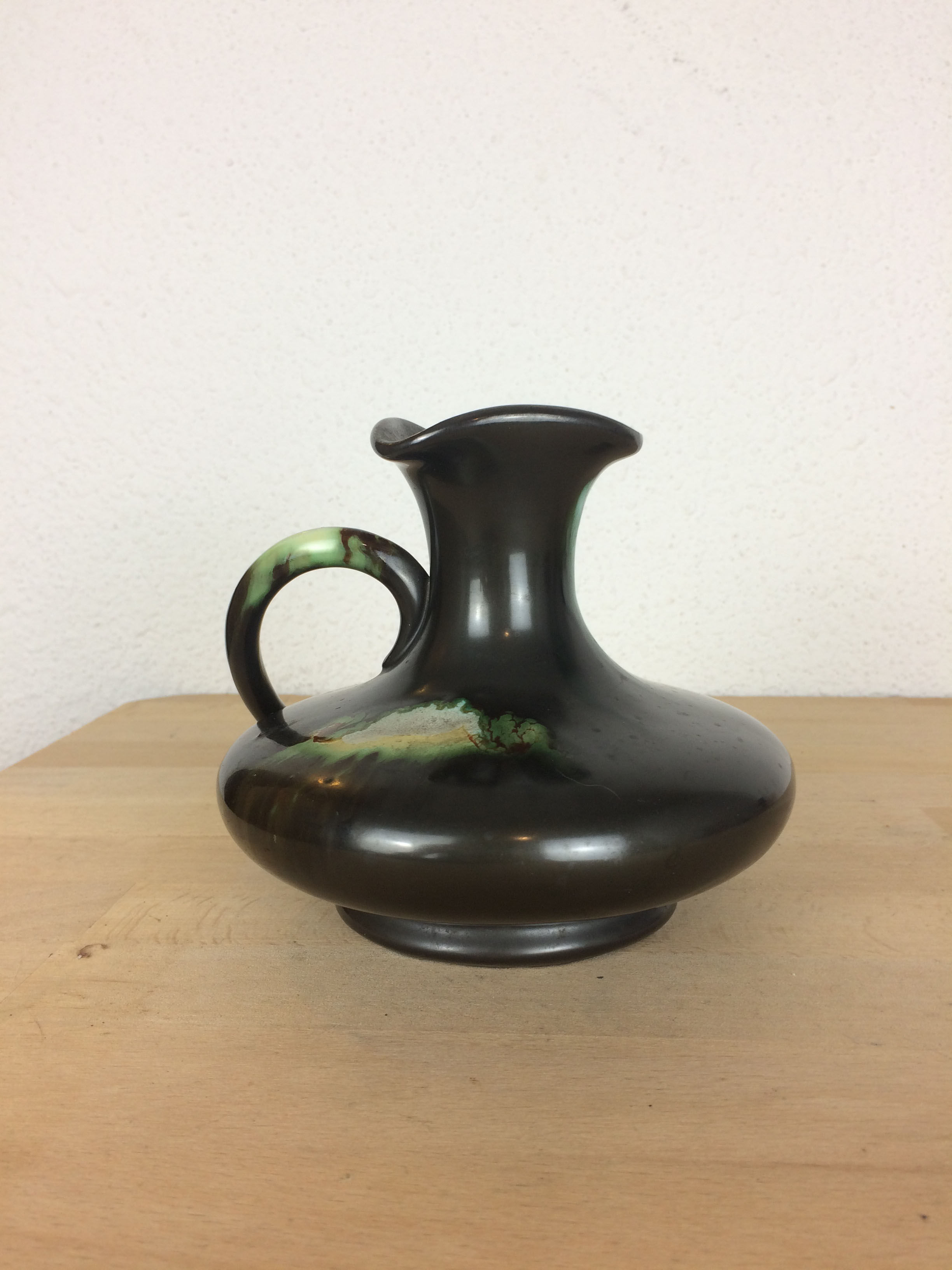 Thulin Belgium pitcher, black ceramic handle