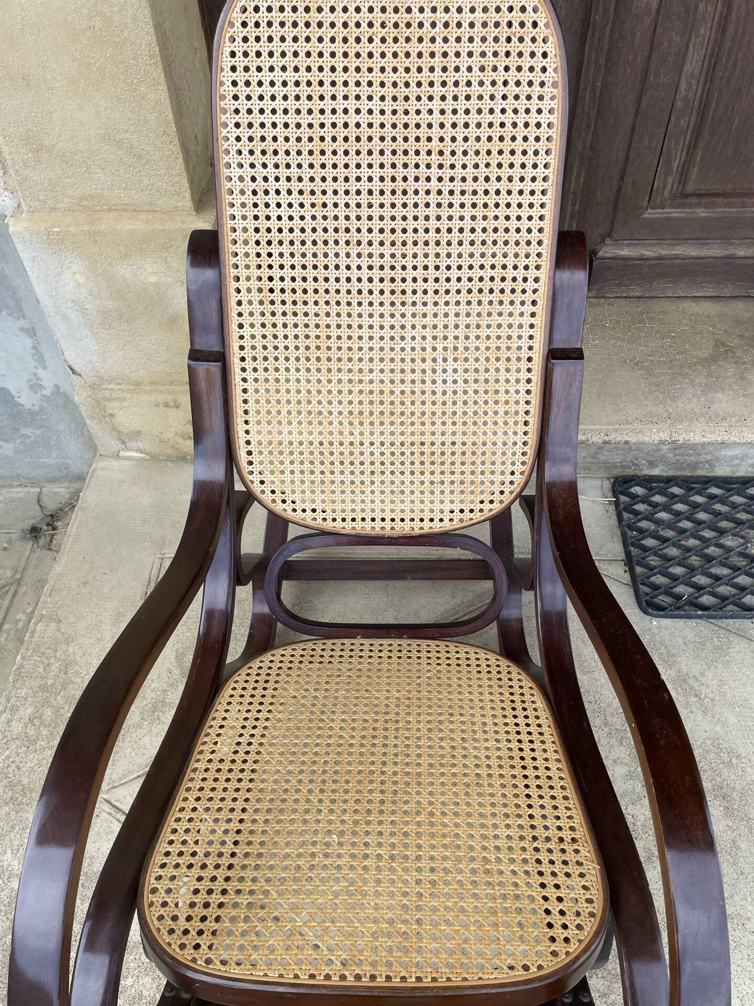 Curved wooden rocking chair with caning