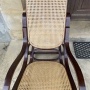 Curved wooden rocking chair with caning