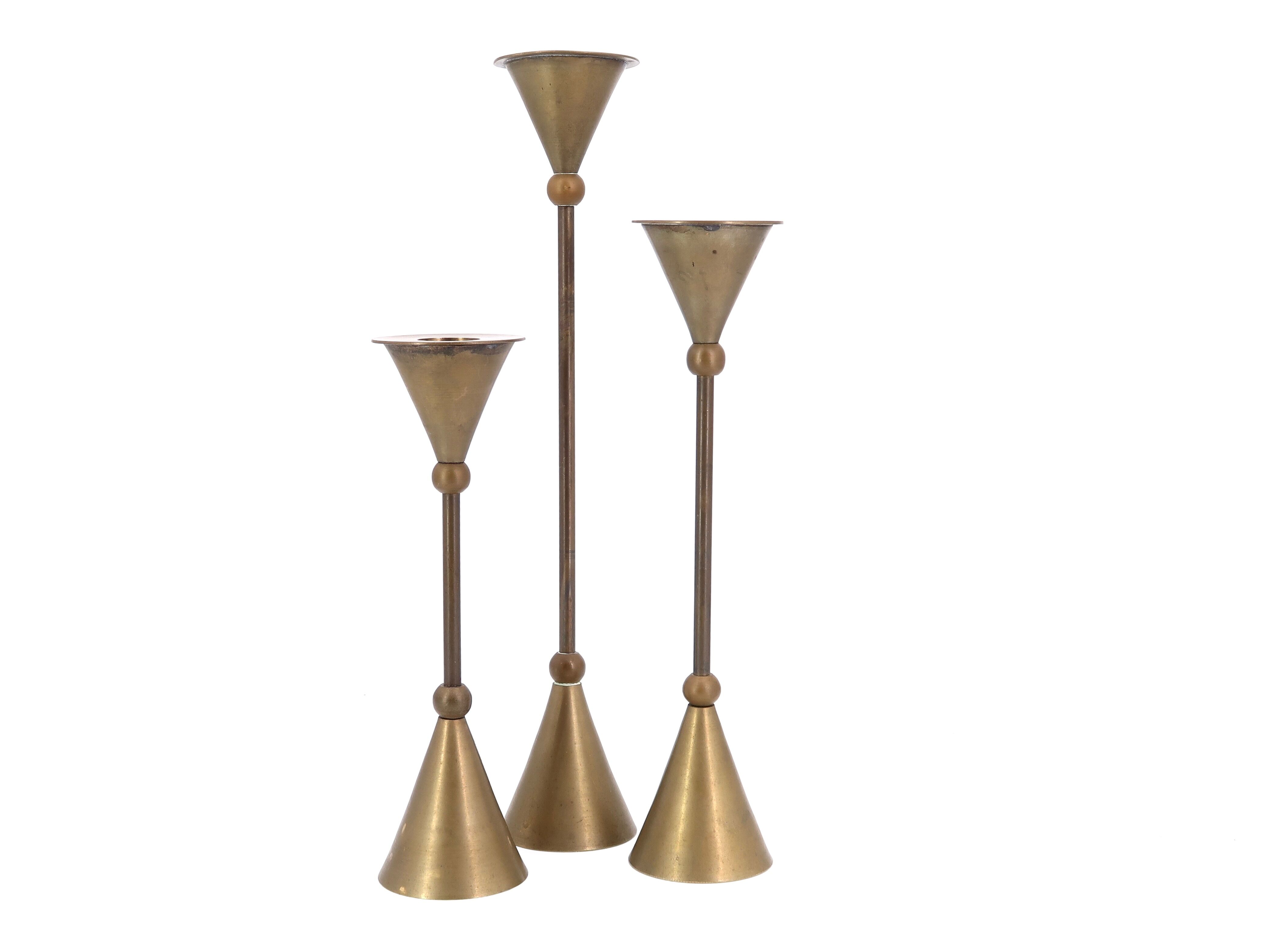 Trio of brass candlesticks by Christian de Beaumont