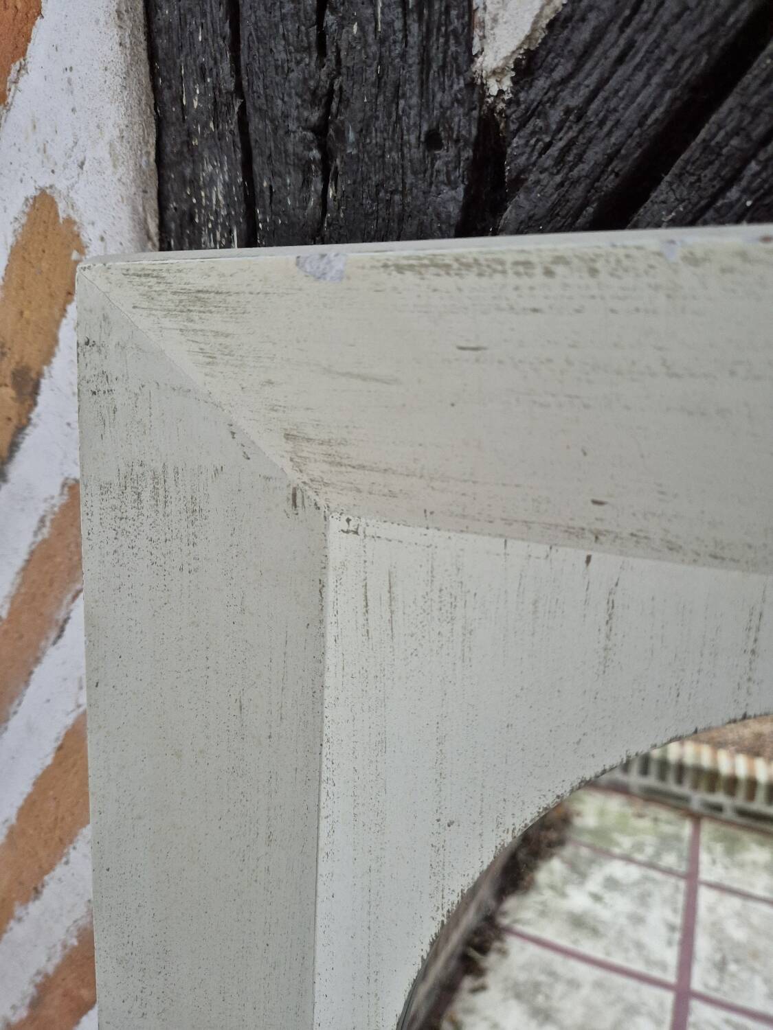 Oval mirror with a distressed white frame