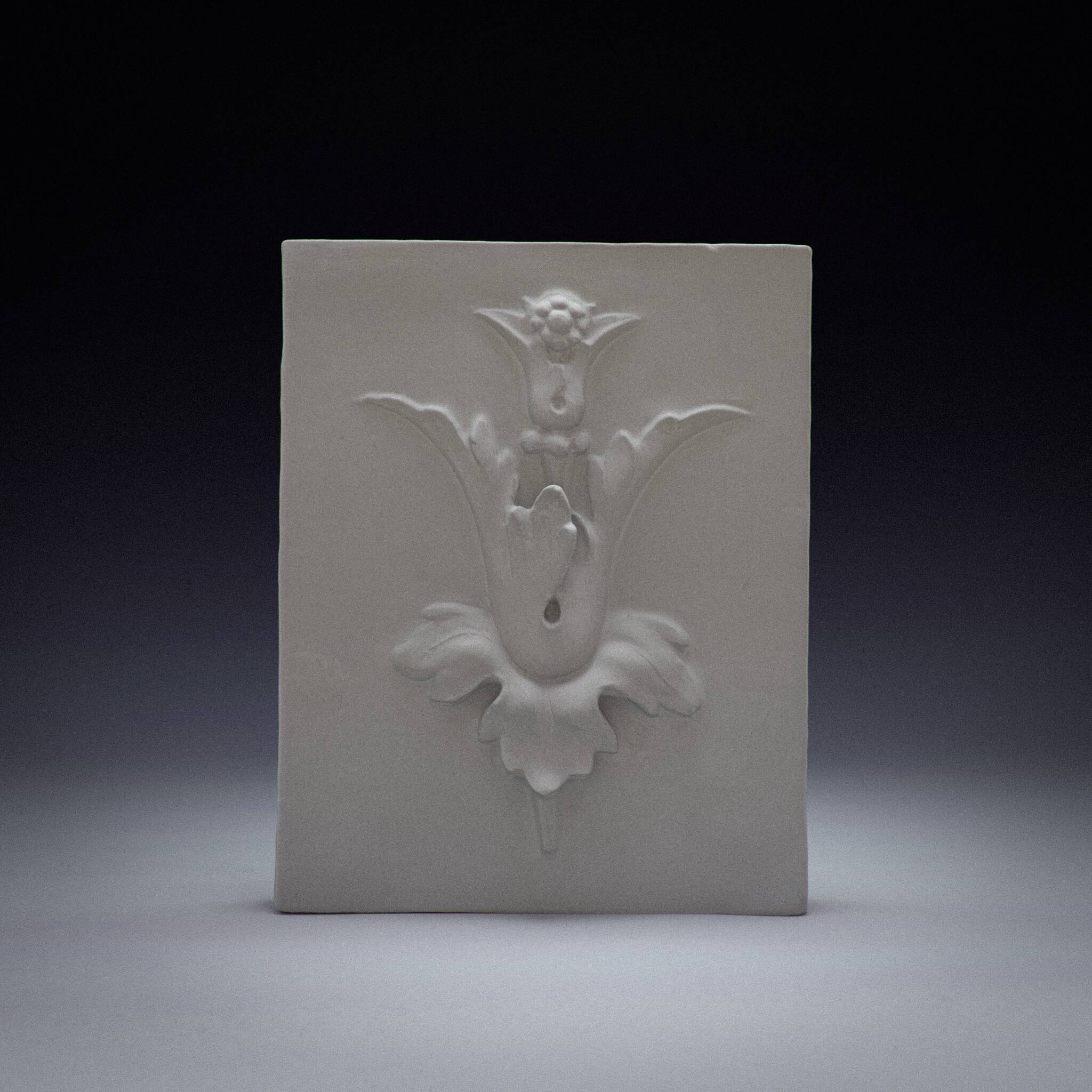 Bas-relief plaster mural with a fleur-de-lis design.