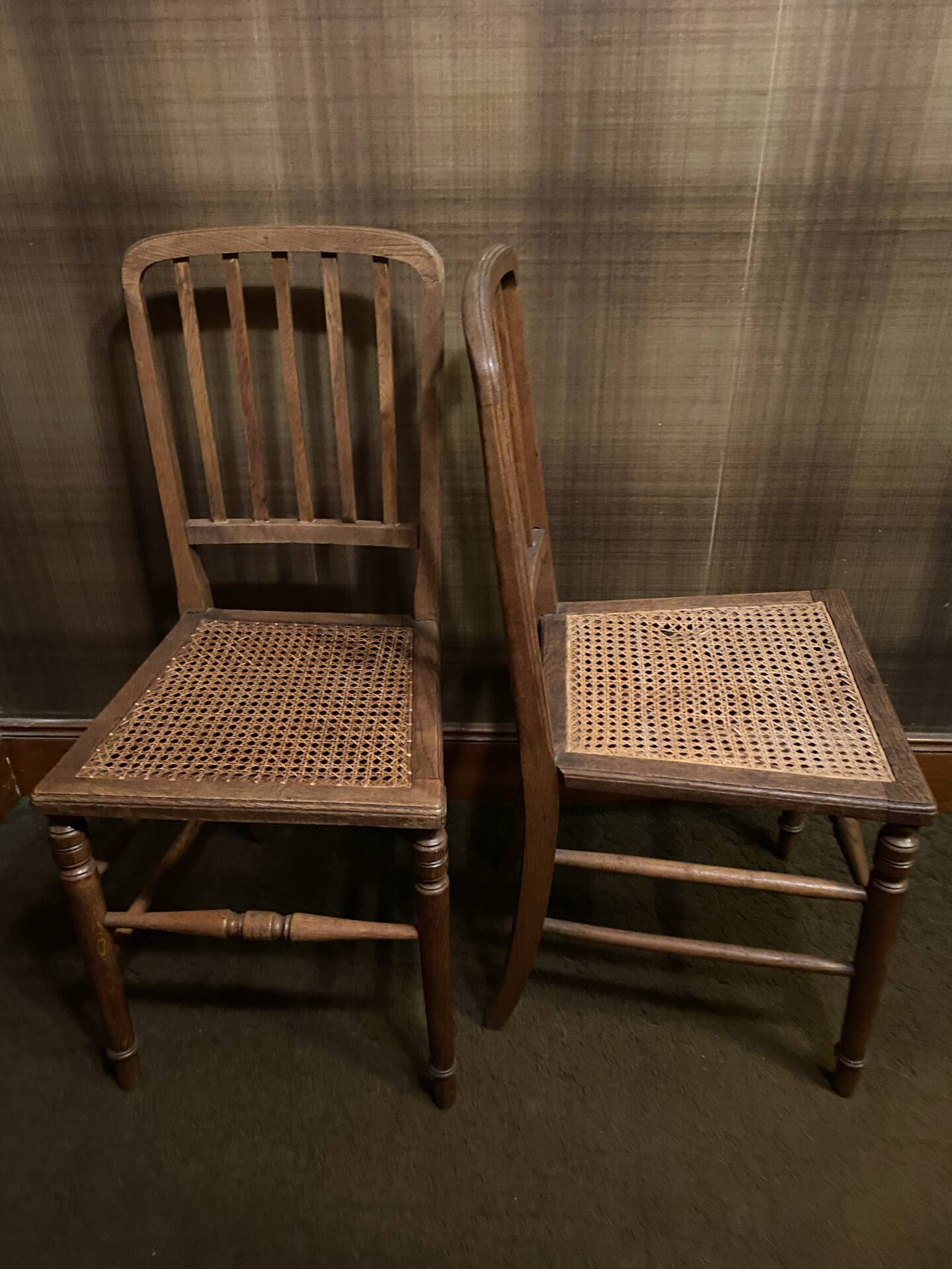 Set of 2 antique wooden chairs with caned seats.
