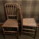 Set of 2 antique wooden chairs with caned seats.