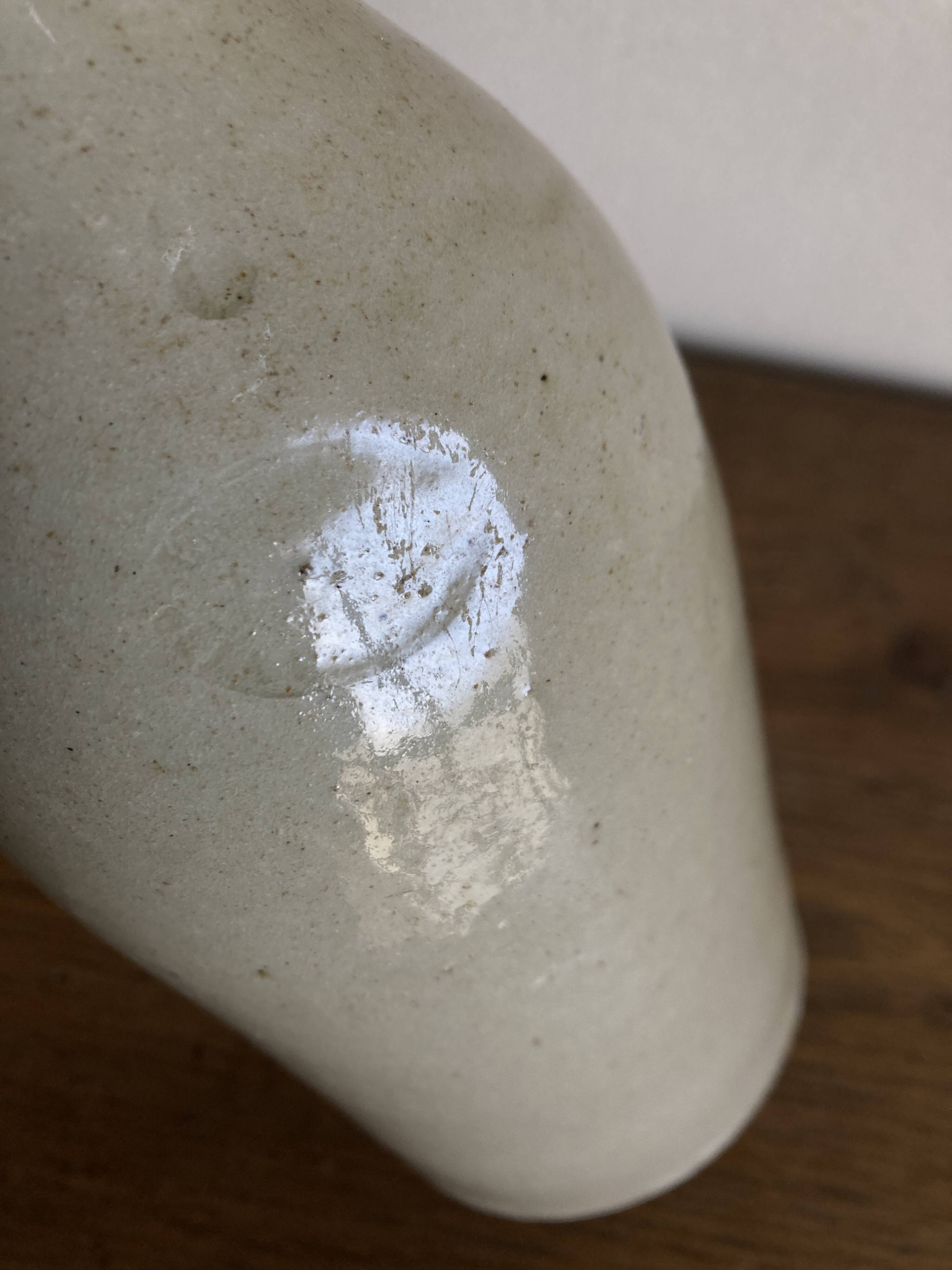 Stoneware bottle tilted at an angle, early 20th century