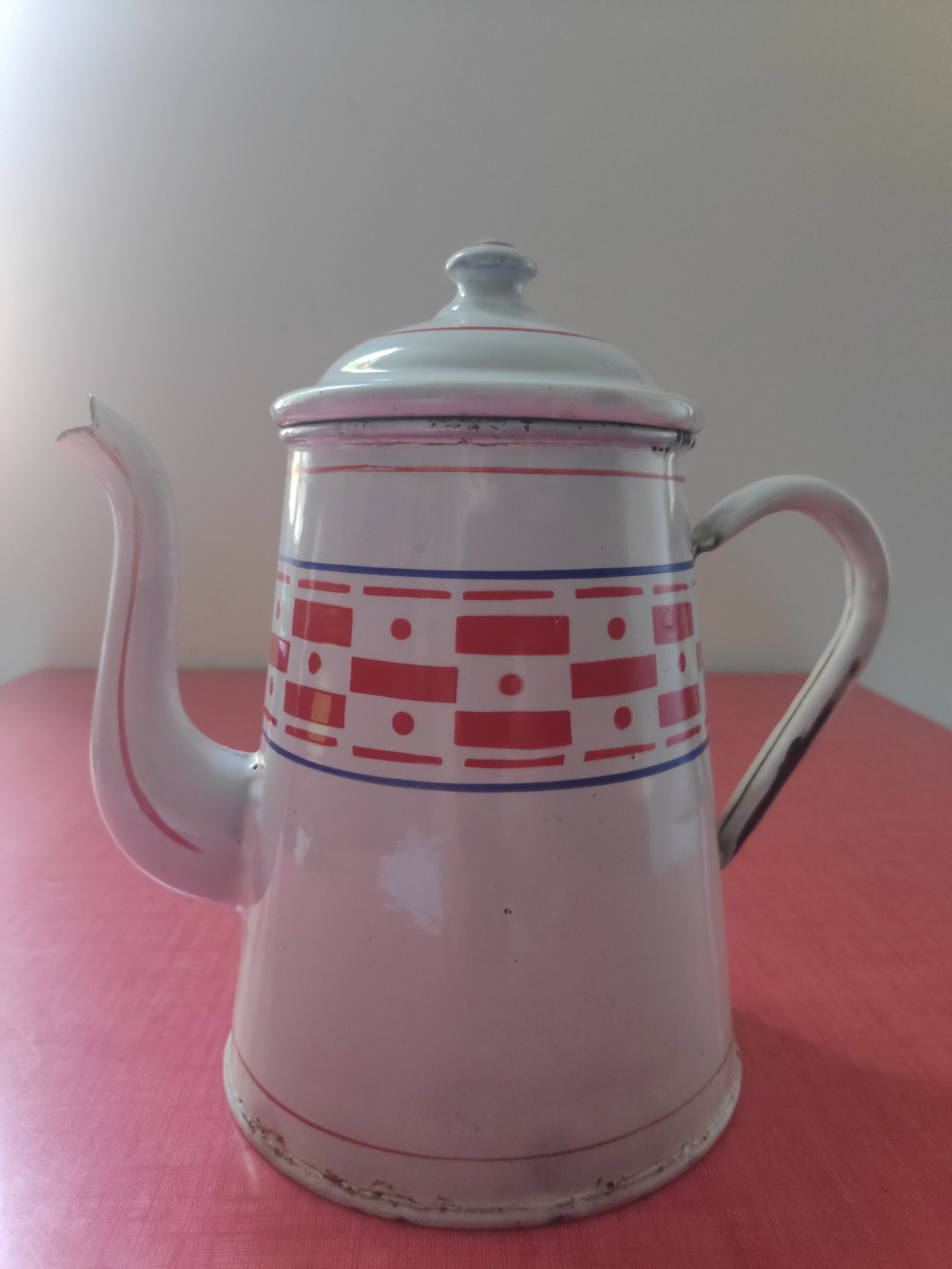 White enamelled sheet metal coffee maker with red and blue patterns