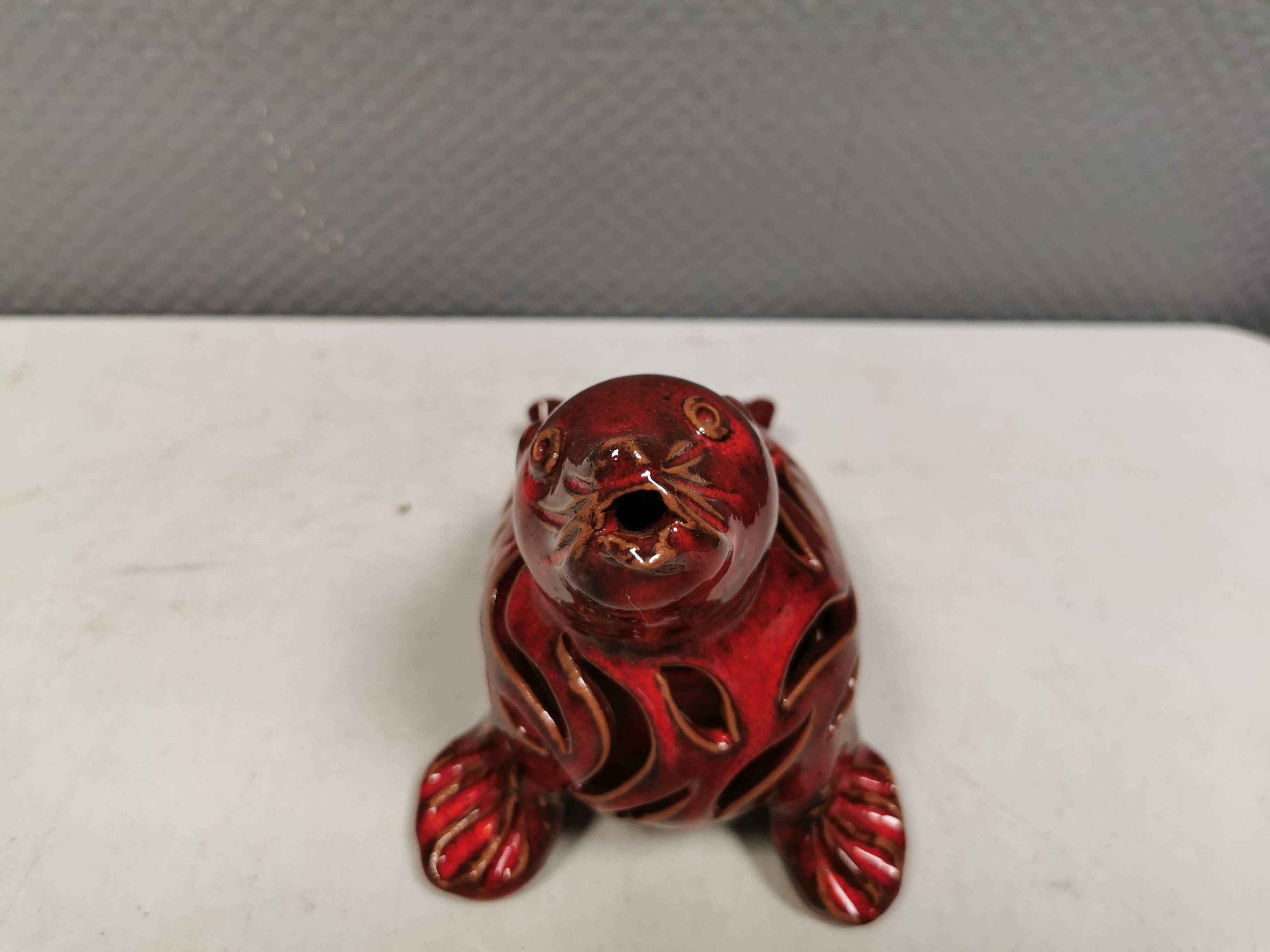 Beautiful seal in ceramic with metallic red glaze.