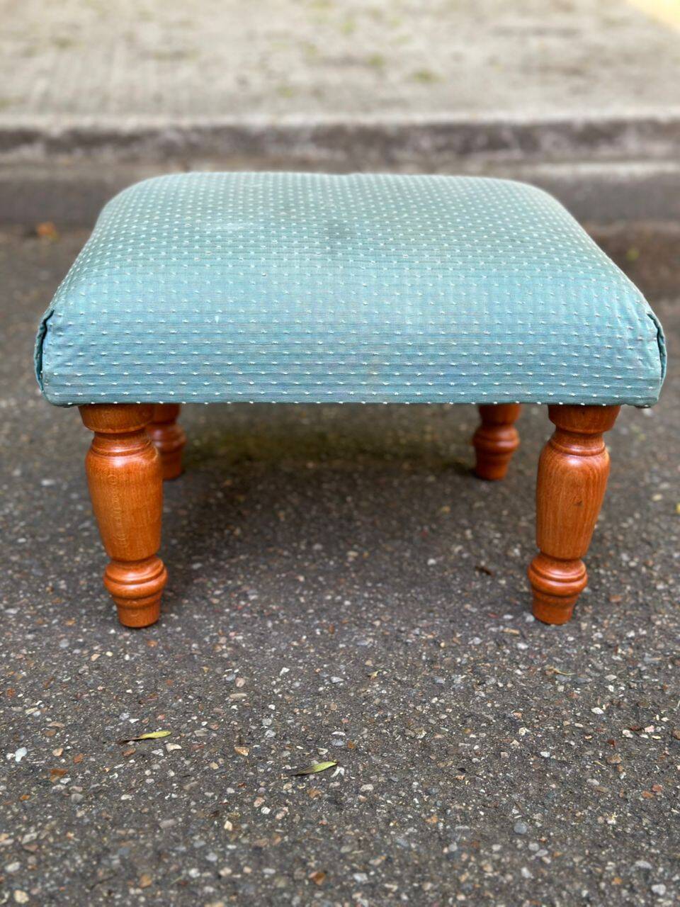 Vintage footstool made of solid wood and blue fabric.