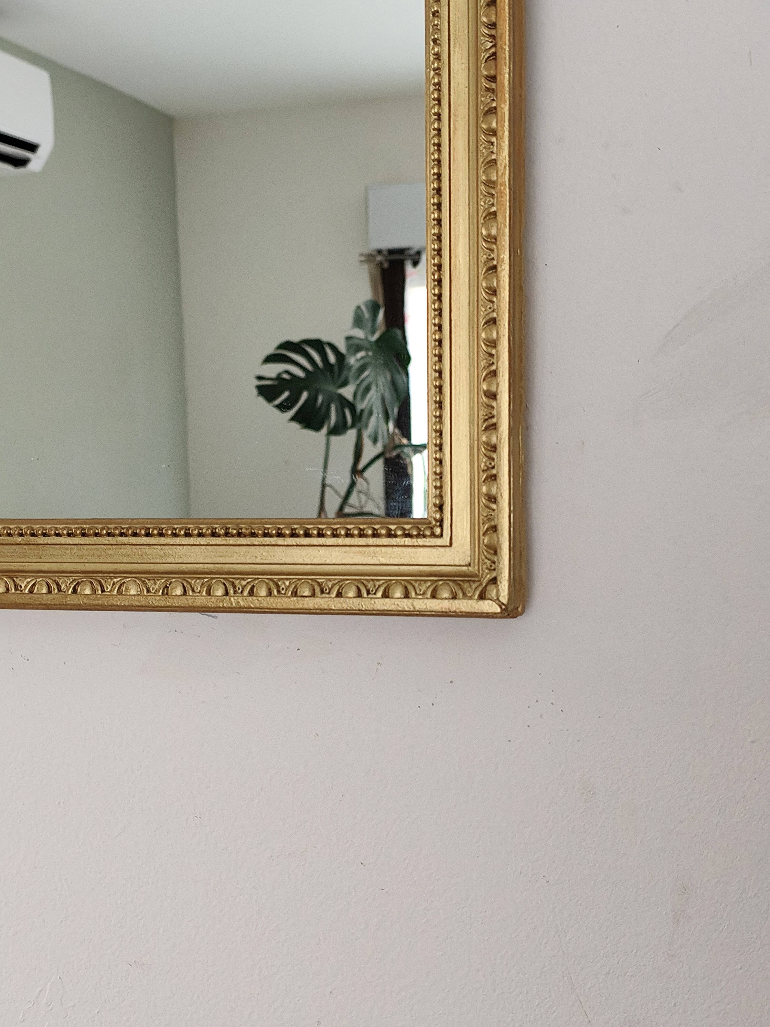 Antique mirror with a gilded frame and beaded border.