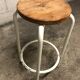 Vintage bar stool in white lace-up, round wooden seat rests circular feet