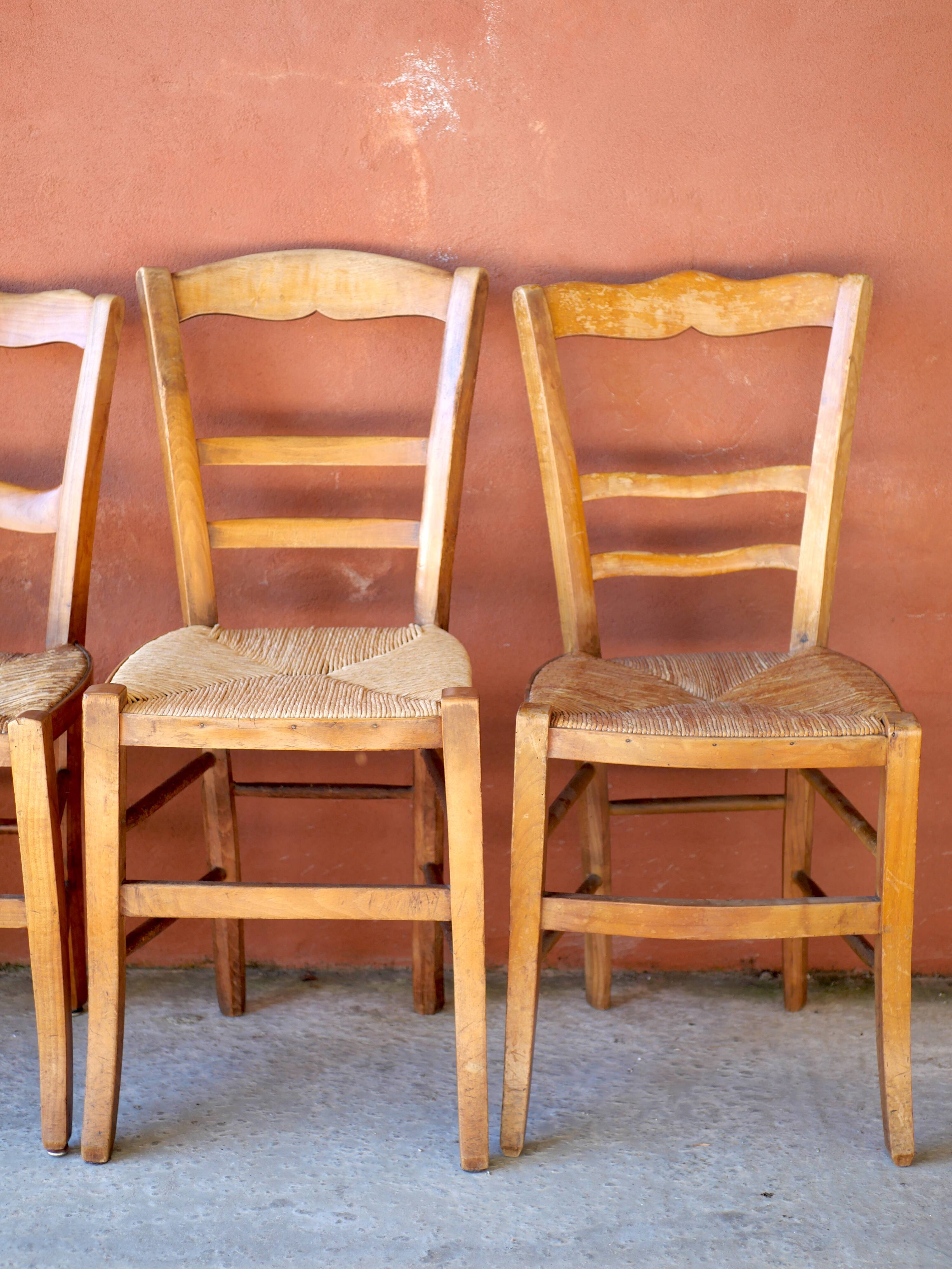Set of 5 mismatched straw chairs.