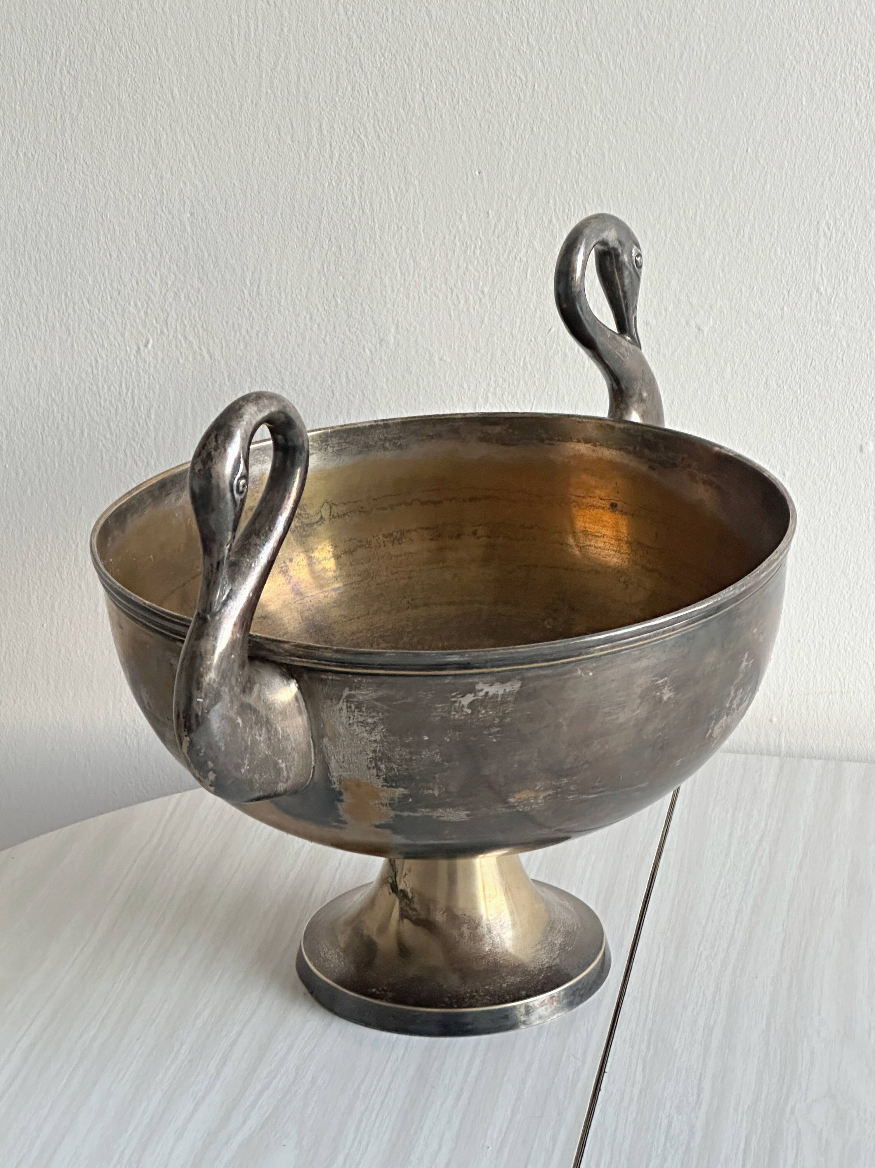 Large champagne bucket with patinated metal swan handles.