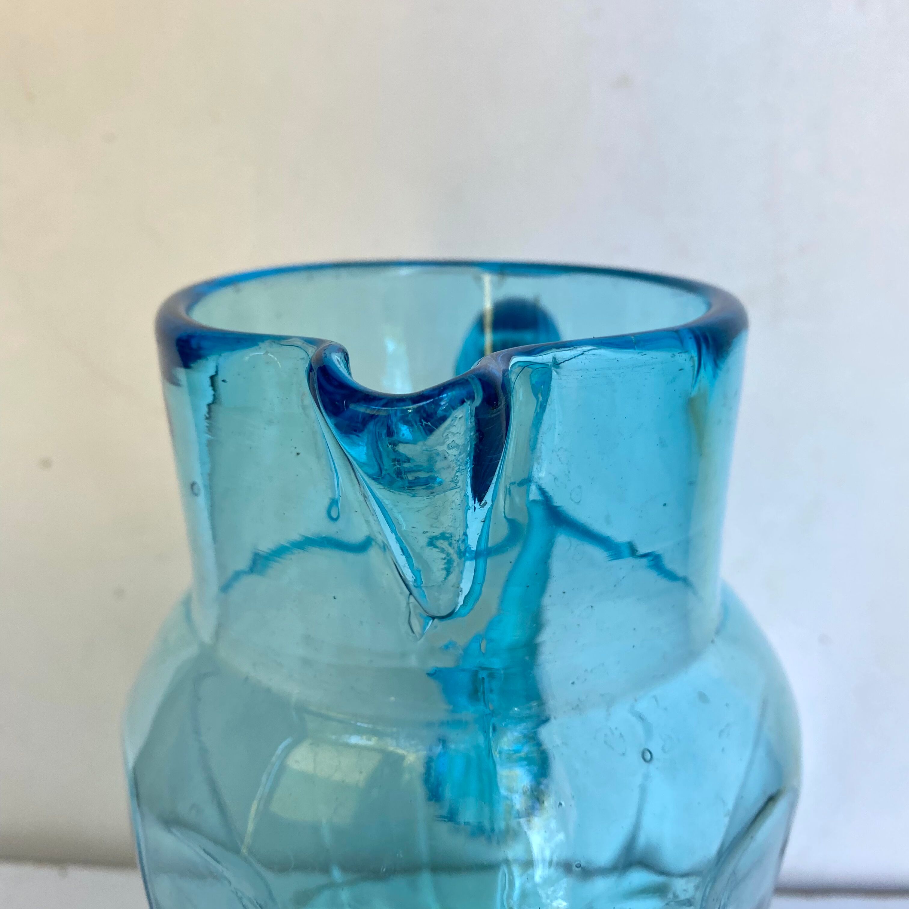 Old pitcher in blue glass